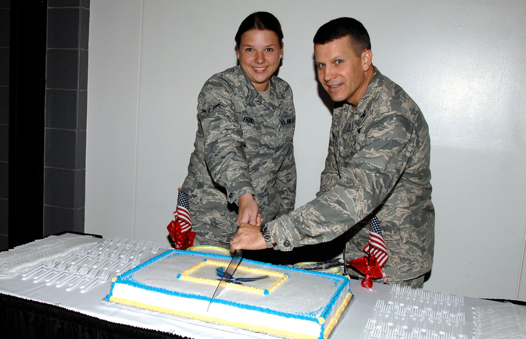 Airman Sarah Fiquet, 22nd Logistics Readiness Squadron, and Col. James Crowhurst, 22nd Air Refueling Wing commander cut a cake during a ceremony at McConnell Air Force Base, Kan., Sept. 18, 2009, celebrating the Air Force’s 62nd birthday. Traditionally, the lowest and highest ranking Airmen at the ceremony cut the cake. (U.S. Air Force photo/Senior Airman Anthony Mejia)

