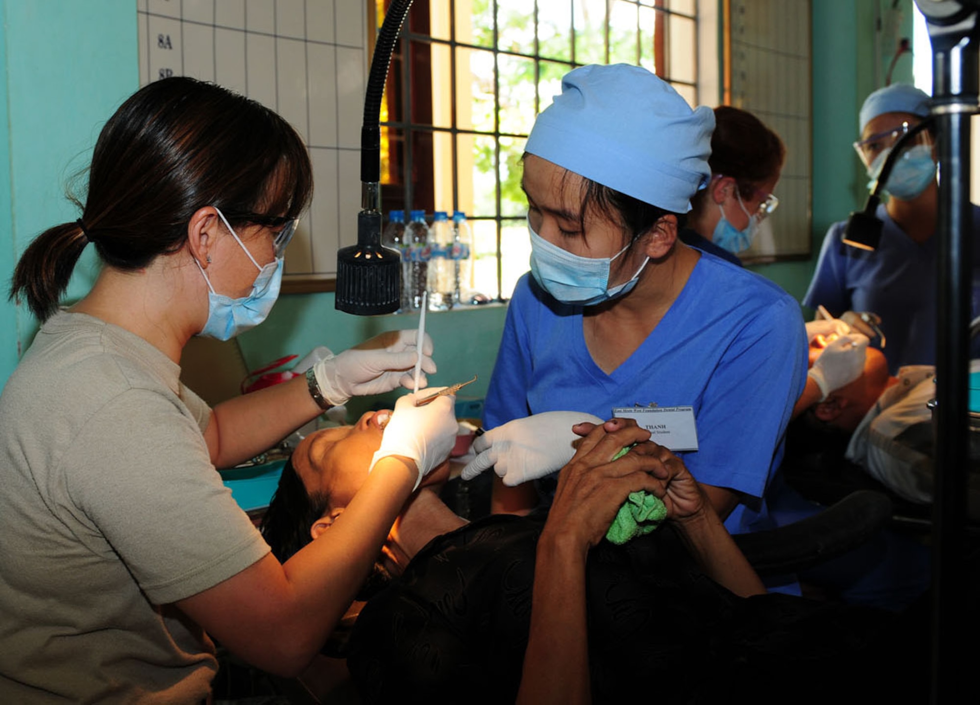 Maj. (Dr.) Diep Le (left) provides dental care to a Vietnamese patient Sept. 18, 2009, as part of Operation Pacific Angel 2009 in Quang Tri Province, Vietnam. Doctor Le is part of a team of Air Force medical professionals and civil engineers in Vietnam providing humanitarian assistance in cooperation with local authorities to Quang Tri Province residents Sept. 15 to 24. Pacific Angel is a Pacific Air Forces operation led by 13th Air Force at Hickam Air Force Base, Hawaii. The joint and combined humanitarian assistance operation is conducted in the Pacific area of responsibility to support U.S. Pacific Command's capacity-building efforts. Doctor Le is a dentist and Air Force reservist from Travis Air Force Base, Calif. (U.S. Air Force photo/Tech. Sgt. Kerry Jackson) 
