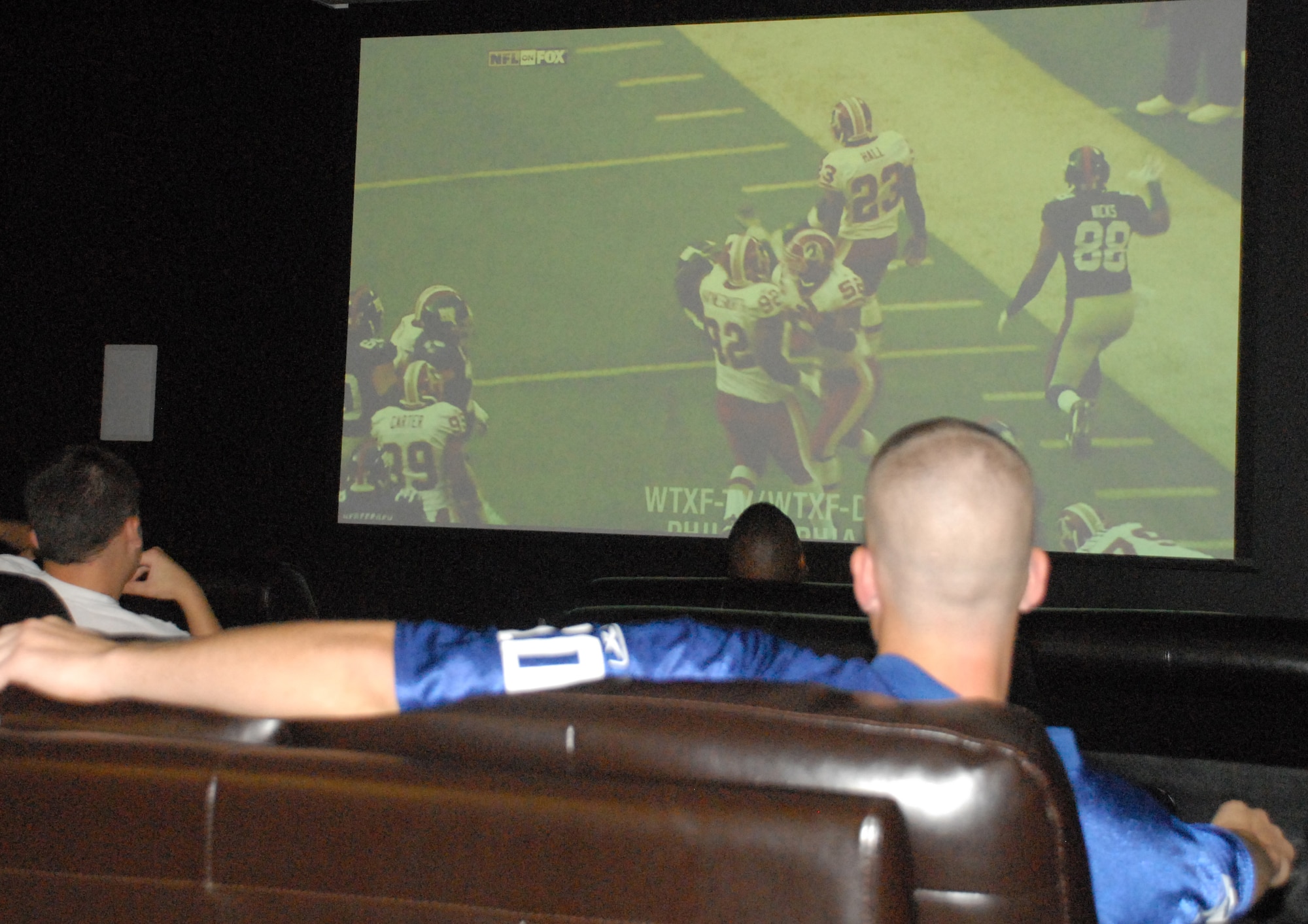 Air Force members watch a football game on a 15 foot tall projection screen at the Eagle Lanes Bowling Center Sept. 13 as part of Football Frenzy.  The event included a buffet, give aways and a contest for Superbowl tickets. (U.S. Air Force photo/Staff Sgt. Chad Padgett)