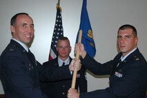 Lt. Col. Michael Burns (left), 302nd Mission Support Group commander, hands Maj. John Dumont (right) the 302nd Security Forces Squadron guideon during a change of command ceremony Sept. 19 at Peterson Air Force Base, Colo. Major Dumont, the squadron's new commander, said he feels "lucky" to be part of the squadron's "professionals." (U.S. Air Force photo/Tech. Sgt. Daniel Butterfield)