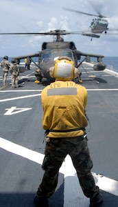 USS MESA VERDE, Gulf of Mexico — A landing signal enlisted Sailor and two Army UH-60 Blackhawk helicopter aircrew members, assigned to Joint Task Force-Bravo, watch as a Navy SH-60B Knighthawk helicopter lifts off the flight deck of the amphibious transport dock landing ship USS Mesa Verde (LPD 19) Sept. 15. Mesa Verde is underway for Fuerzas Alidas (FA) PANAMAX 2009.  FA PANAMAX is an annual U.S. Southern Command joint and multi-national training exercise tailored to the defense of the Panama Canal, involving civil and military forces from around the world. (U.S. Navy photo/Mass Communication Specialist 3rd Class Patrick Grieco).