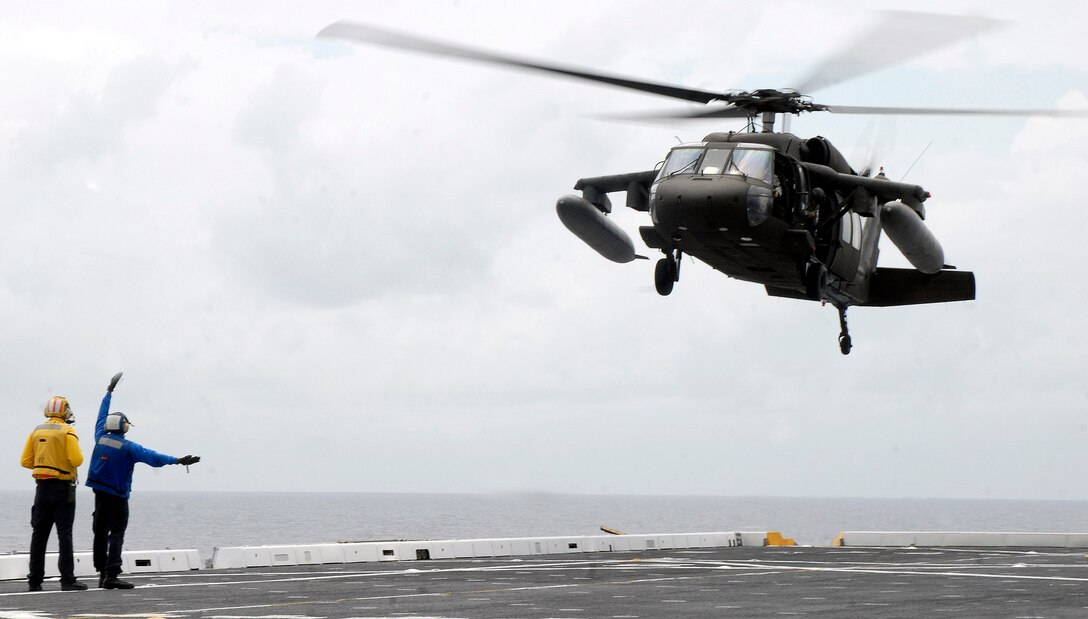 USS MESA VERDE, Panama — An Air department Sailor guides in an Army UH-60 Blackhawk, assigned to Joint Task Force-Bravo, onto the flight deck of the amphibious dock landing ship USS Mesa Verde (LPD 19) during deck landing qualifications Sept. 14.  Mesa Verde is underway for Fuerzas Alidas (FA) PANAMAX 2009.  FA PANAMAX is an annual U.S. Southern Command joint and multi-national training exercise tailored to the defense of the Panama Canal, involving civil and military forces from around the world. (U.S. Navy photo/Mass Communication Specialist 3rd Class Patrick Grieco).