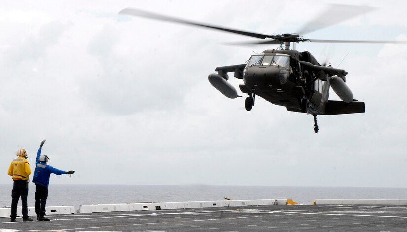 USS MESA VERDE, Panama — An Air department Sailor guides in an Army UH-60 Blackhawk, assigned to Joint Task Force-Bravo, onto the flight deck of the amphibious dock landing ship USS Mesa Verde (LPD 19) during deck landing qualifications Sept. 14.  Mesa Verde is underway for Fuerzas Alidas (FA) PANAMAX 2009.  FA PANAMAX is an annual U.S. Southern Command joint and multi-national training exercise tailored to the defense of the Panama Canal, involving civil and military forces from around the world. (U.S. Navy photo/Mass Communication Specialist 3rd Class Patrick Grieco).