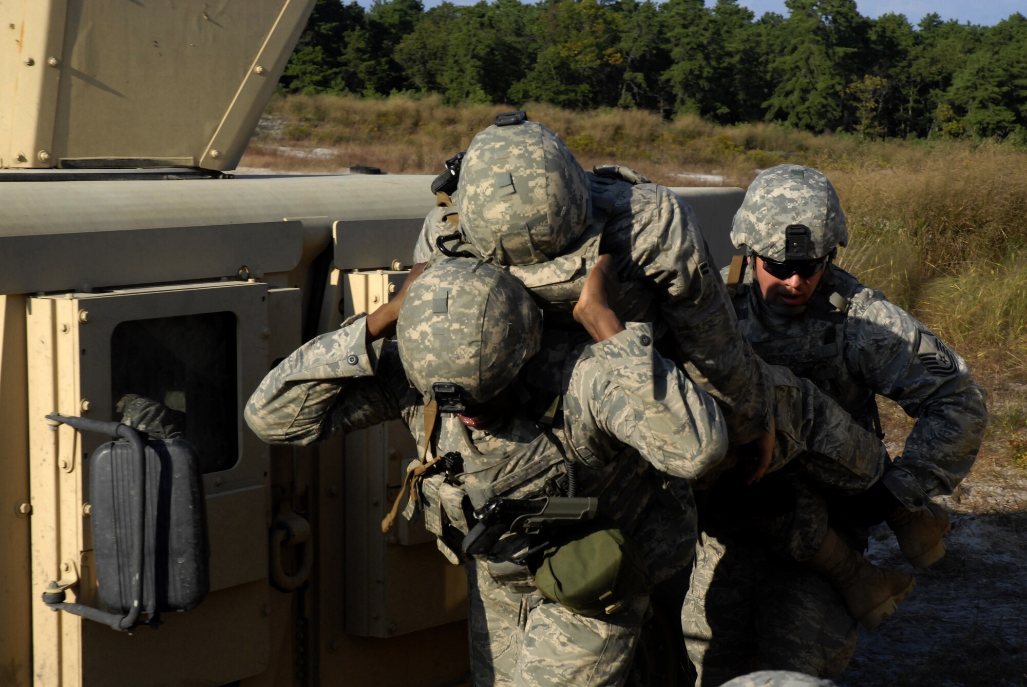Security forces Airmen evacuate an injured Airman to safety after a simulated explosion of an improvised explosive device disabled his vehicle in their convoy during a pre-deployment training exercise conducted by the U.S. Air Force Expeditionary Center's 421st Combat Training Squadron at Joint Base McGuire-Dix-Lakehurst, N.J. on September 15, 2009.  (U.S. Air Force photo/Tech. Sgt. Paul R. Evans)