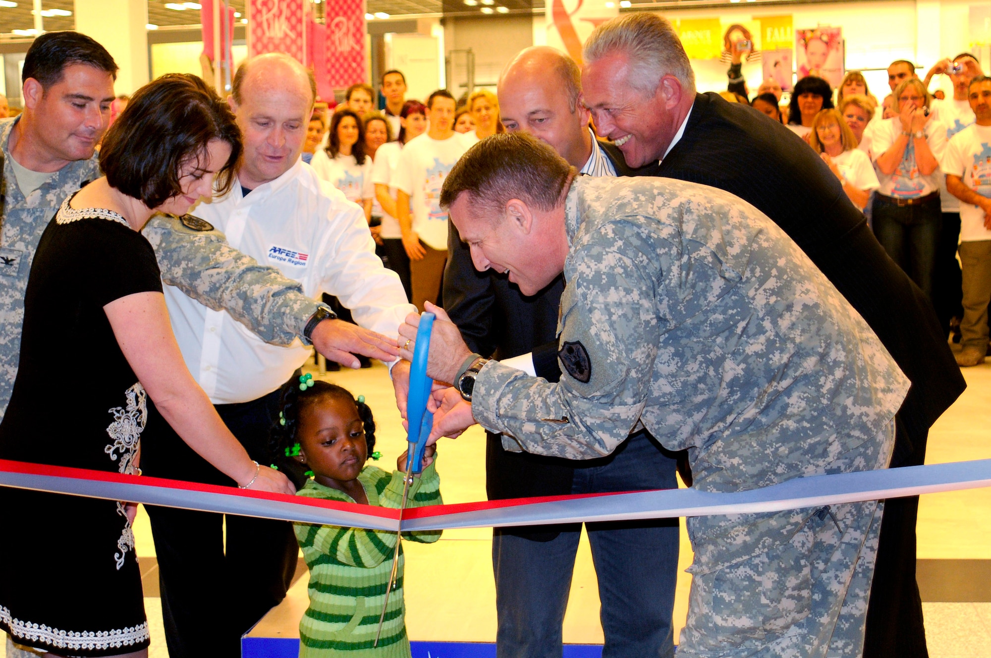 U. S. Army Maj. Gen. Keith L. Thurgood, AAFES commander, assists Jayda Hall, age three, with the scissors during the Kaiserslautern Military Community Center grand opening ribbon cutting ceremony along with Stephanie Burns, store manager, U. S. Army Col. Chuck Salvo, AAFES Europe and Southwest Asia Region commander, Jack Morris, AAFES-Europe senior vice president, Tom Gross, general manager, and Winfried Sahuch, project manager, Ramstein, Germany, Sept. 21, 2009. (U.S. Air Force photo by Tech. Sgt. Kenneth Bellard)