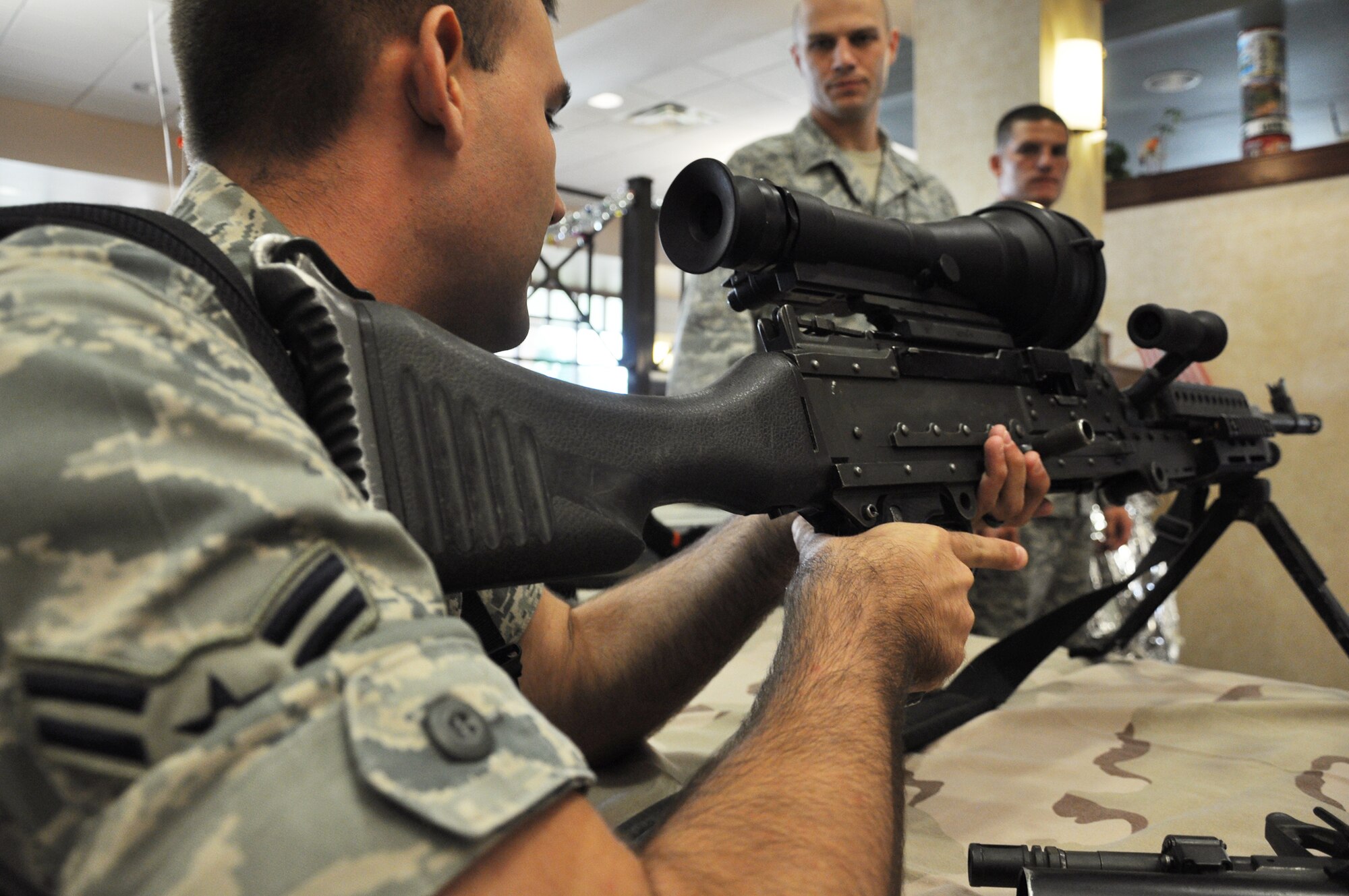 Airman 1st Class Nicolas Aguilar, 1st Special Operations Wing, checks out a Raptor 6 scope mounted on an M2-40B machine gun at the dining facility as part of the 96th Ground Combat Training Squadron’s weapons and training tools display Sept. 18.  (U.S. Air Force photo/Airman 1st Class Chris Jacobs)