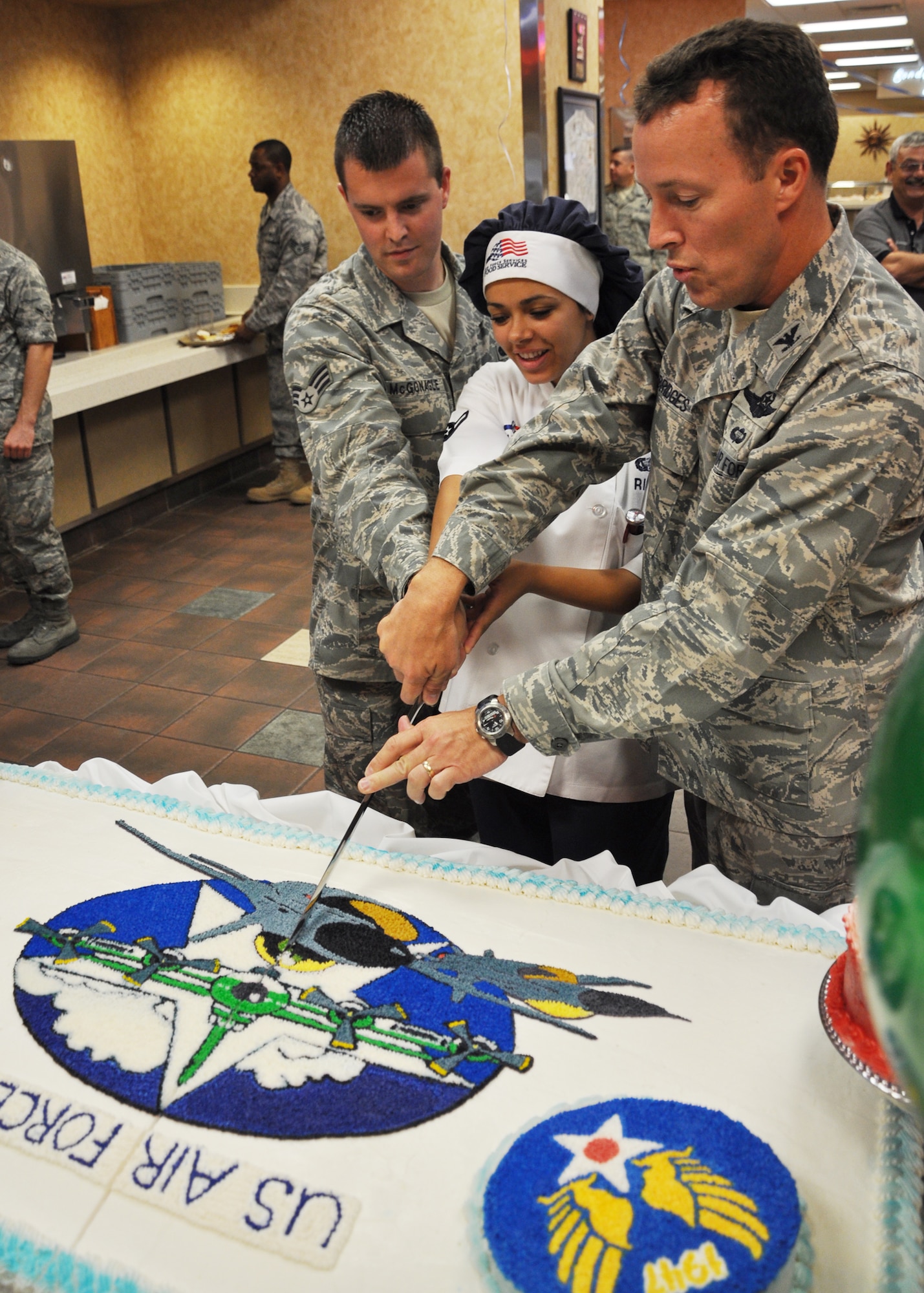 (Left to right) Senior Airman Robert Mcgonagle, Airman Erin Rich, 96th Force Support Squadron, and Col. Alan Bridges, 96th Mission Support Group cut the Air Force birthday cake with a ceremonial saber.  The cake consisted of 12 separate cakes and took approximately 30 hours of work.  The cake was served Sept 18 during lunch at the Breeze dining facility.   (U.S. Air Force photo/Airman 1st Class Chris Jacobs)
