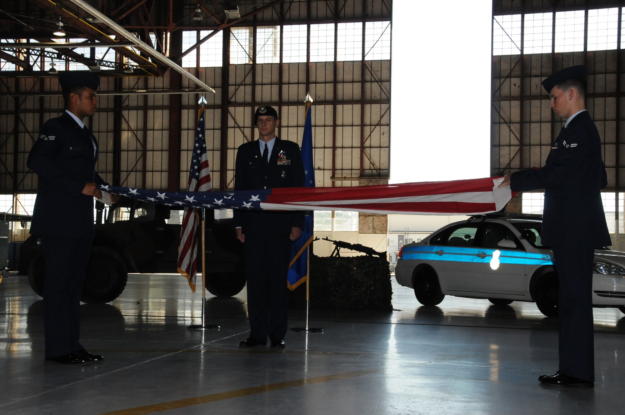 SEYMOUR JOHNSON AIR FORCE BASE, N.C. -- Maj. Jeff Poupart (center), stands proudly during the flag folding ceremony held during his retirement on Sept. 13. Maj. Poupart served more than 25 years and ended his military career as commander of the 916th Security Forces Squadron. U.S. Air Force photo by: TSgt. Scotty Sweatt, 916ARW/PA.