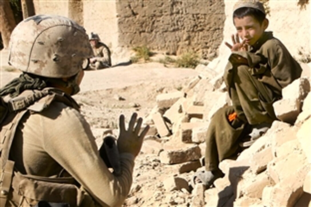 U.S. Navy Petty Officer 3rd Class Paul Zapanta talks with a local Afghan boy during a patrol in Helmand province's Nawa district, Afghanistan, Sept. 7, 2009. Zapanta is a corpsman assigned to the 1st Battalion, 5th Marines, deployed with Regimental Combat Team 3. The Marines are conducting security patrols to speak with the residents to identify their issues and concerns.