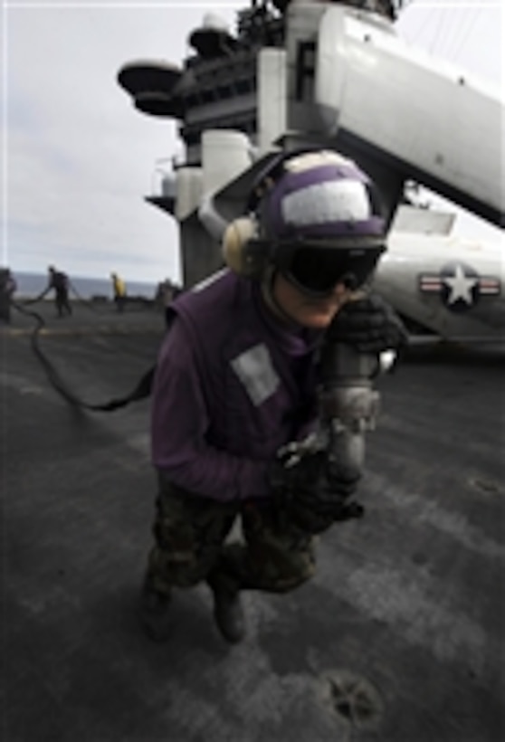 U.S. Navy Airman Joshua Hube drags a fuel hose across the flight deck of the aircraft carrier USS John C. Stennis (CVN 74) in order to refuel an F/A-18C Hornet aircraft from Strike Fighter Squadron 125 in the Pacific Ocean on Sept. 16, 2009.  The Stennis is in transit to southern California to participate in fleet replacement carrier qualifications.  