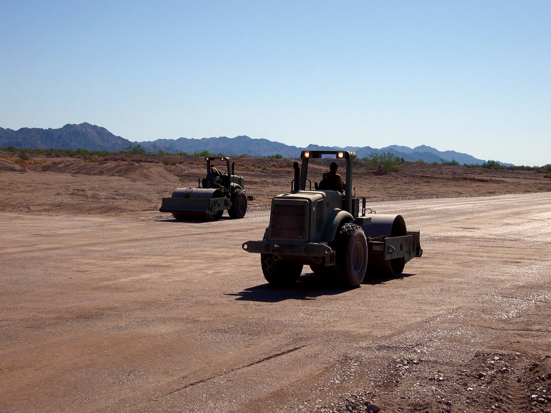 Two Marine Wing Support Squadron 374 heavy equipment operators smooth and compact an unmanned aircraft system runway at the Chocolate Mountain Aerial Gunnery Range in Calif., Sept. 21, 2009. The runway, which was the first built for UASs on the ranges of the Marine Corps Air Station in Yuma, Ariz., will open up new training opportunities for UASs visiting for the Weapons and Tactics Instructor course. Marine Unmanned Aerial Vehicle Squadron 1 will be the first squadron to use the runway during their training in the current WTI.