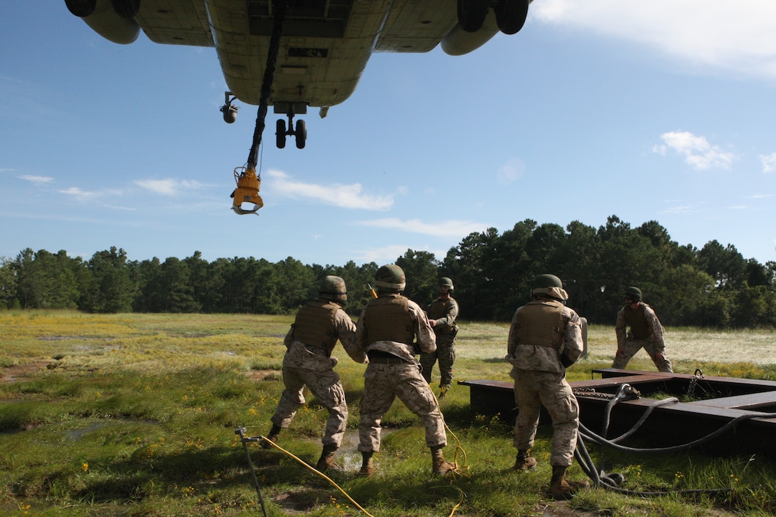 LOS Marines get ready to hook up a grounding cable to the helicopter during an evaluation at Landing Zone Kite on Marine Corps Base Camp Lejeune, Sept. 23.