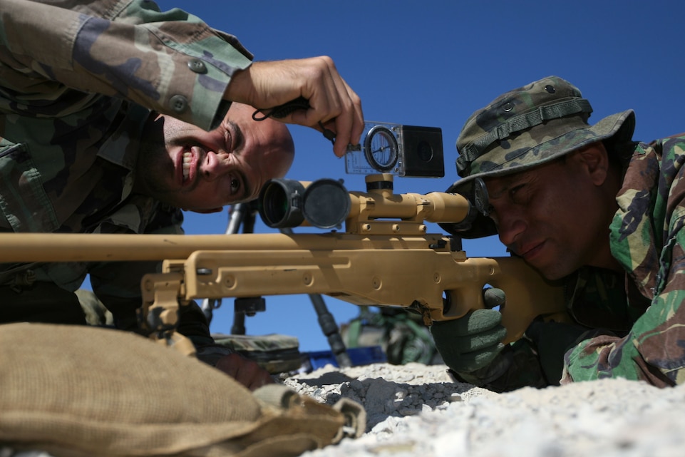 Cpl. Stefan Brouwers, a sniper with Sniper Team, 24th Co., 2nd Battalion, Royal Dutch Marines, makes adjustments to Sgt. Vince Manusama's, a sniper with Sniper Team, 24th Co., 2nd Battalion, Royal Dutch Marines, rifle just before a live-fire exercise atop Rocket Mountain here Tuesday. Brouwers said the road to becoming a sniper was rough but well worth the work.