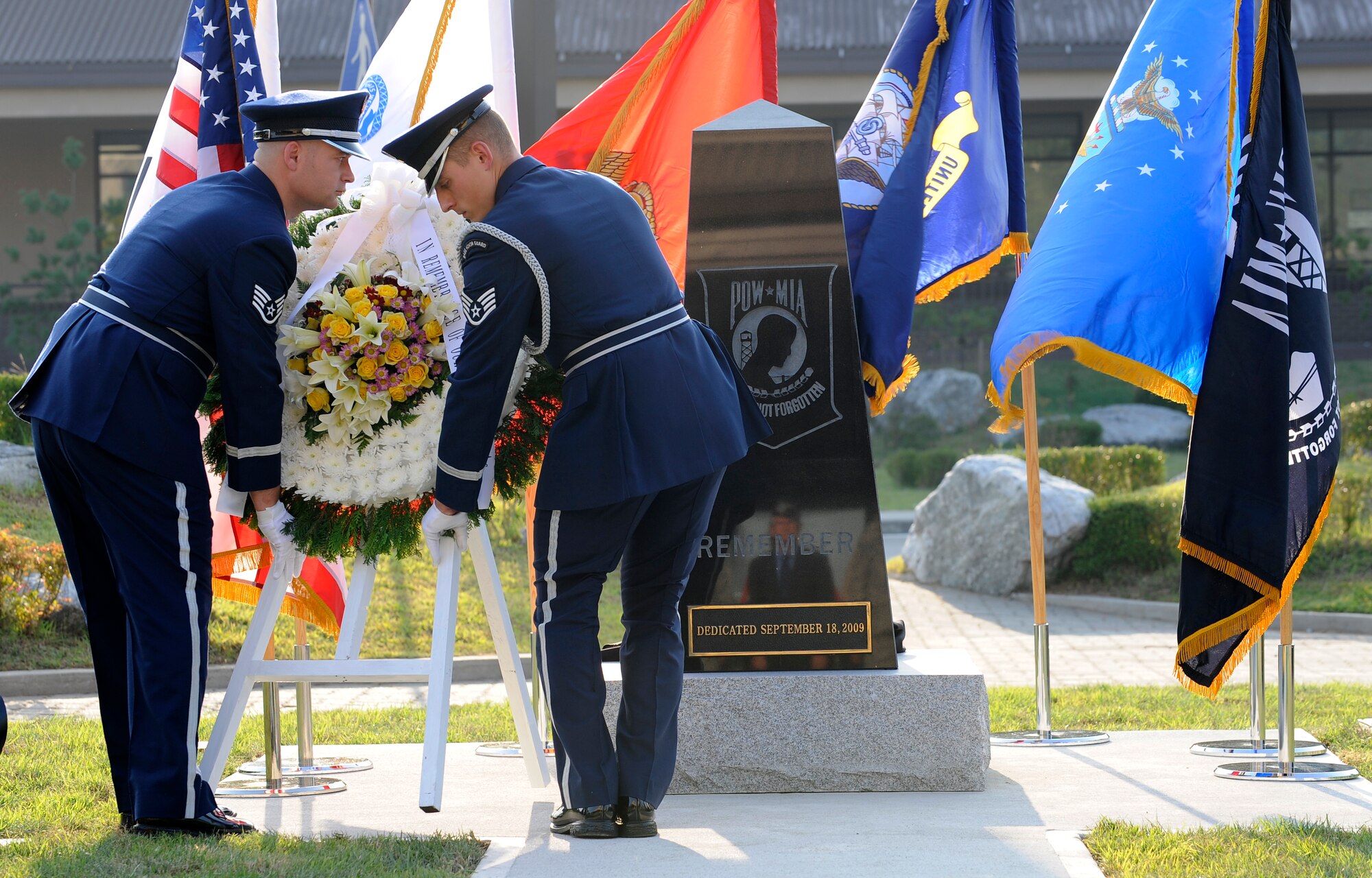 Osan Air Base honor guard Airmen lay a wreath in front of a POW/MIA remembrance statue during a dedication ceremony in front of the base theater Sept. 18.  The ceremony honored those who sacrificed so much for their country. (U.S. Air Force photo/Staff Sgt. Brian Ferguson)