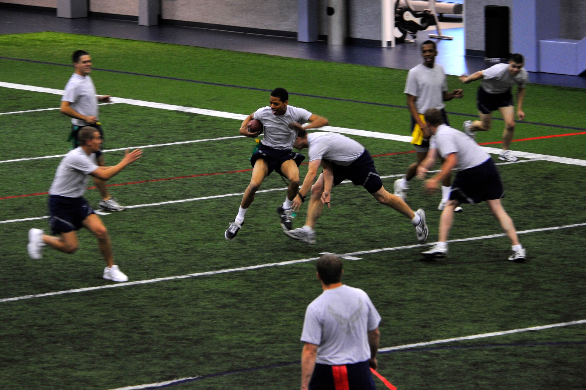 A group of Airmen play flag football at the Baker Field House Sept. 22, 2009, Eielson Air Force, Base, Alaska. There are many health activities and events available to the base provided by the Fitness Center and the Health and Wellness Center staff. (U.S. Air Force photo/Staff Sgt. Christopher Boitz)