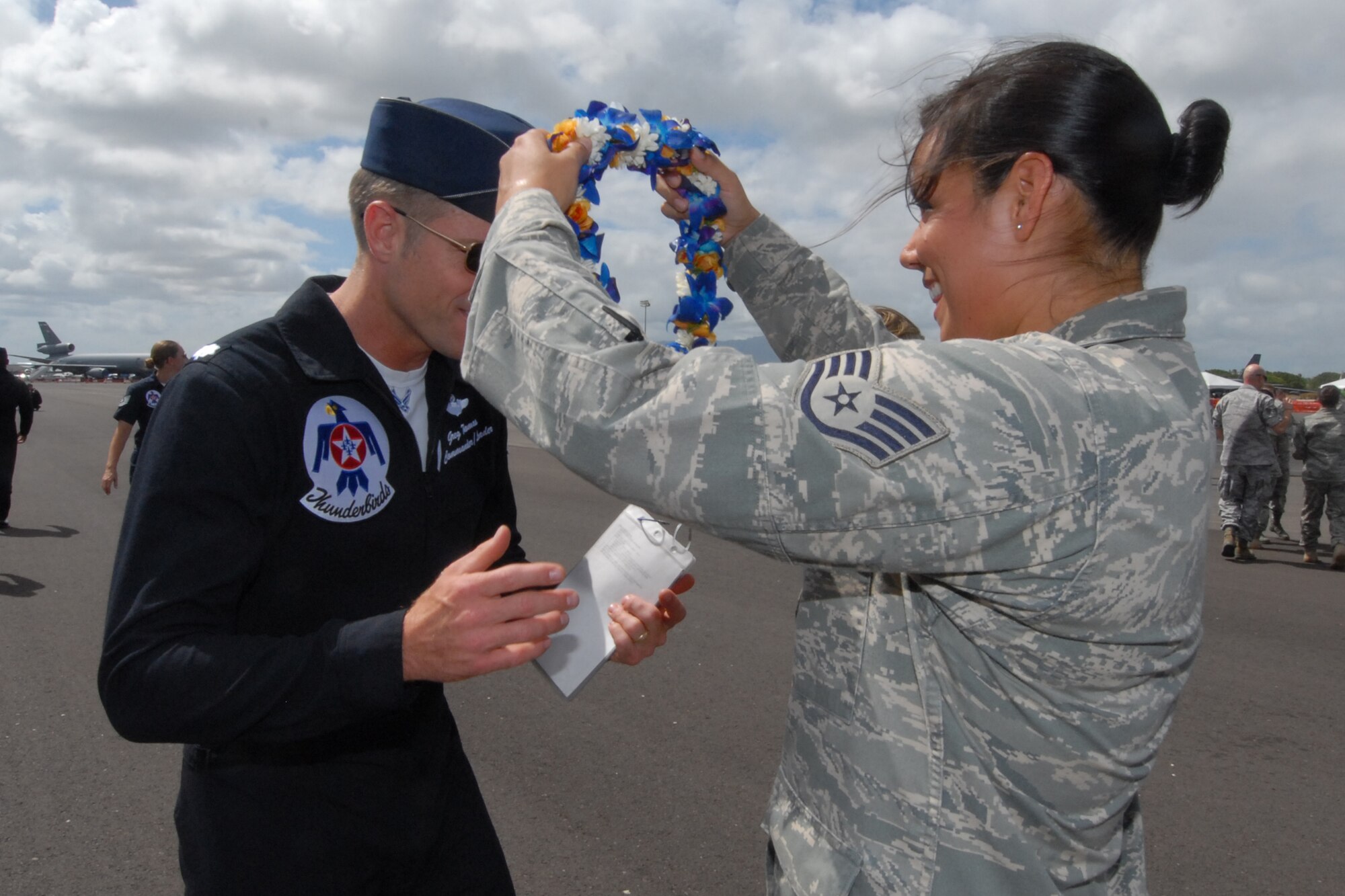 HICKAM AIR FORCE BASE, Hawaii -- Staff Sgt. Casey Hanson, 17th Weather Squadron, presents a lei of thanks to Lt. Col. Greg Thomas, U.S. Air Force Thunderbird #1 Commander, for conducting a reenlistment ceremony for her and six other Airmen Sept. 18. The ceremony, before an exclusive crowd of family and friends, was conducted prior to the Thunderbirds taking to the skies. The Airmen who reenlisted were: Senior Master Sgt. Orville White, Staff Sgt. Travis Dixon, Staff Sgt. Ehtan Ervin, Staff Sgt. Casey Hanson, Staff Sgt. Mary Kimberly, Staff Sgt. Charles Nelson and Senior Airman Elyana Soto. They reenlisted on the Air Force's 62nd birthday. Friends and family members were a planeside to witness the event. (U.S. Air Force photo/Staff Sgt. Mike Meares)