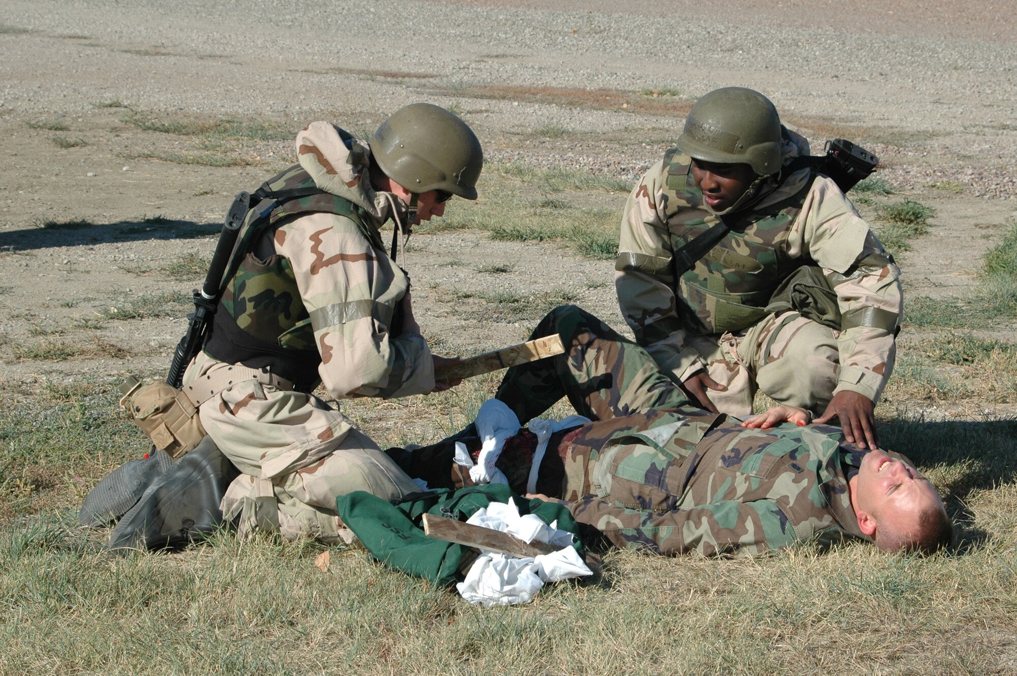 Airmen 1st Class James Skare and Tarell Register, 341st Logistics Readiness Squadron, tie a splint to Senior Airman Matthew Splichal, 341st Missile Wing Safety Office ground safety technician, during a Self Aid and Buddy Care exercise Sept. 17 at Camp Grizzly. (U.S. Air Force photo/Senior Airman Dillon White)