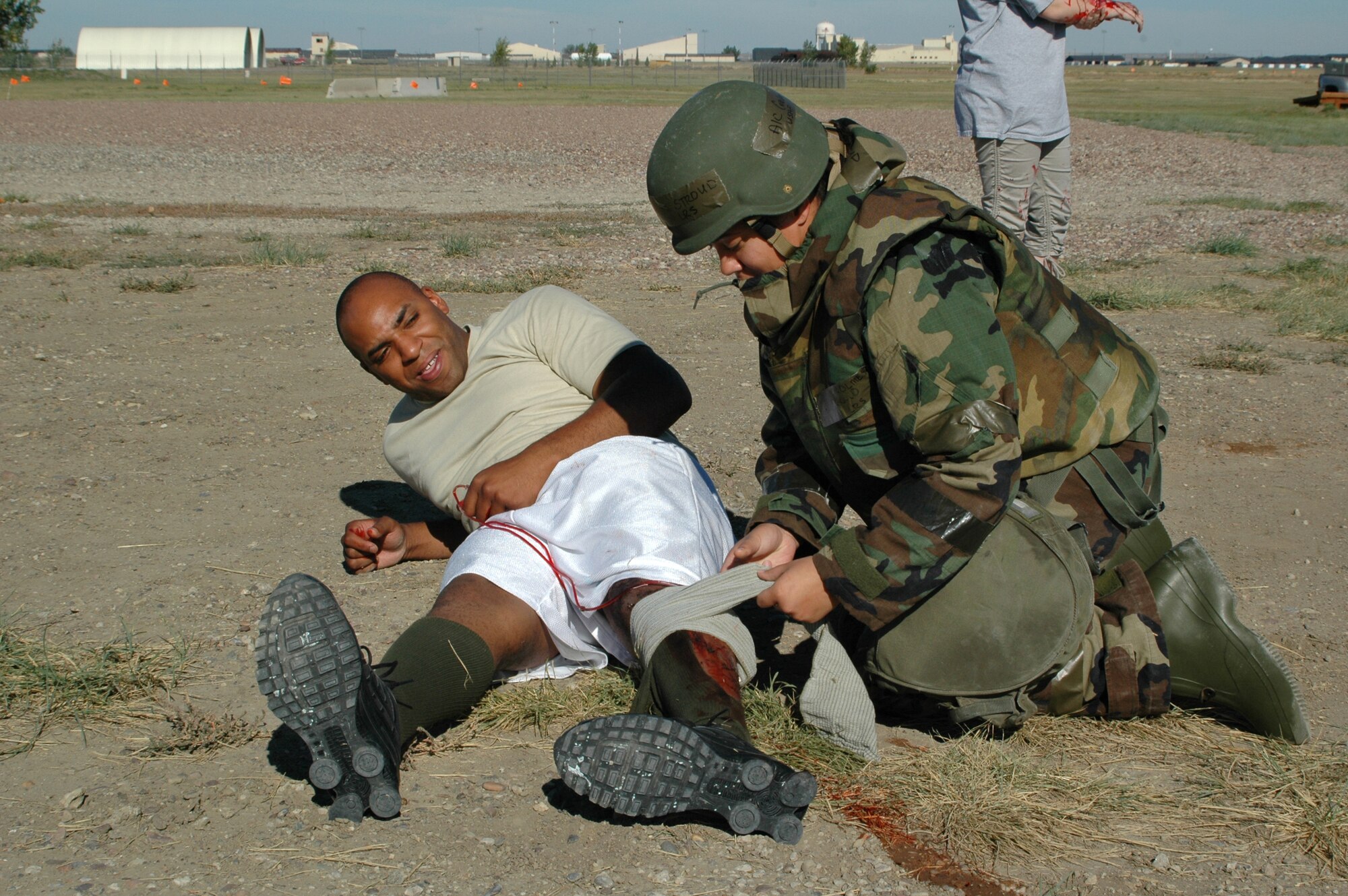 Airman 1st Class Carolmesha Stroud, 341st Logistics Readiness Squadron traffic management apprentice, applies a bandage to Senior Airman Walter Falls, 12th Missile Squadron missile chef, during a Self-Aid and Buddy Care exercise Sept. 17 at Camp Grizzly. (U.S. Air Force photo/Senior Airman Dillon White)