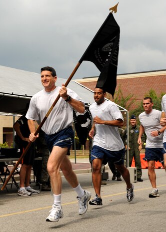 Col. Joseph Mancy kicks off the Charleston AFB 24-hour vigil run held in honor of prisoners of war and those listed as missing in action, leading participants with the POW/MIA flag at the commissary here Sept. 18. The run symbolized prisoners? of war nonstop resistance to enemy interrogation, harsh conditions endured during captivity and America?s promise to never stop searching for all Americans still missing in action. Colonel Mancy is the 437th Operations Group commander. (U.S. Air Force photo/Senior Airman Katie Gieratz)