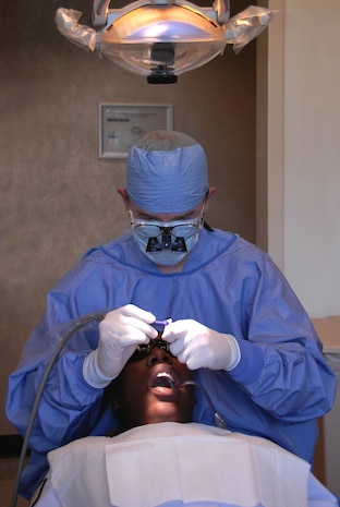 Staff Sgt. Travis Nunn performs a dental cleaning on Tech. Sgt. Idia Cotton-Ferrell at the Deily Dental Clinic here Sept. 21. Sergeant Nunn was recently named a performer of the month for his contributions to the clinic's overall team accomplishments, which include the performance of 420 dental cleanings per month on average. Sergeant Nunn is the NCO in charge of dental logistics and Sergeant Cotton-Ferrell is a support flight NCO, both are with the 437th Medical Group. (U.S. Air Force photo/Staff Sgt. Daniel Bowles)
