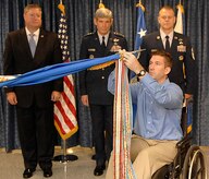 Tech. Sgt. Michael Williams hangs a campaign ribbon on the Air Force flag under the watchful eye of Secretary Michael Donley, Gen. Norton Schwartz and Chief Master Sgt. James Roy during the Airman?s Hall dedication ceremony Sept. 17 at the Pentagon. The Airman?s Hall, located on the fourth floor of the Pentagon, features a multimedia presentation of Air Force leaders, Air Force Medal of Honor recipients and the Outstanding Airmen Display. Sergeant Williams is recovering from injuries sustained during his duty in Afghanistan and is a member of the 437th Civil Engineer Squadron here. Secretary Donley is the Secretary of the Air Force, General Schwartz is the Air Force Chief of Staff and Chief Roy is the Chief Master Sergeant of the Air Force. (U.S. Air Force photo/Andy Morataya)  