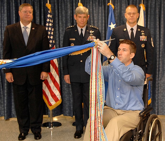 Tech. Sgt. Michael Williams hangs a campaign ribbon on the Air Force flag under the watchful eye of Secretary Michael Donley, Gen. Norton Schwartz and Chief Master Sgt. James Roy during the Airman?s Hall dedication ceremony Sept. 17 at the Pentagon. The Airman?s Hall, located on the fourth floor of the Pentagon, features a multimedia presentation of Air Force leaders, Air Force Medal of Honor recipients and the Outstanding Airmen Display. Sergeant Williams is recovering from injuries sustained during his duty in Afghanistan and is a member of the 437th Civil Engineer Squadron here. Secretary Donley is the Secretary of the Air Force, General Schwartz is the Air Force Chief of Staff and Chief Roy is the Chief Master Sergeant of the Air Force. (U.S. Air Force photo/Andy Morataya)  

