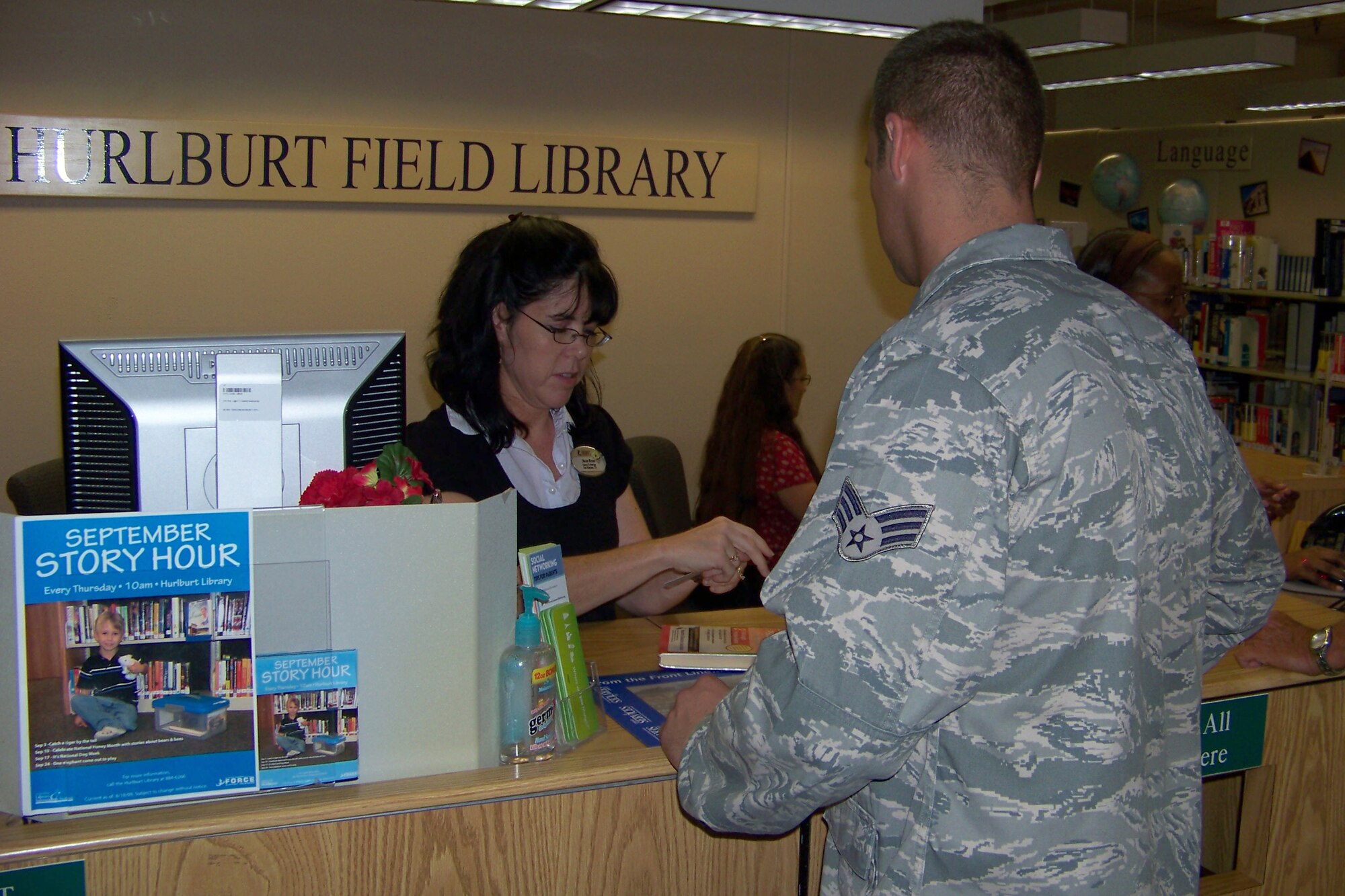 Susie Milam, a Hurlburt Field librarian, helps a customer check out materials Sept. 22. The Hurlburt Field library was recently named both the Air Force library of the year and the Federal library of the year. (U.S. Air Force photo/ 2nd Lt. Victoria Brayton)