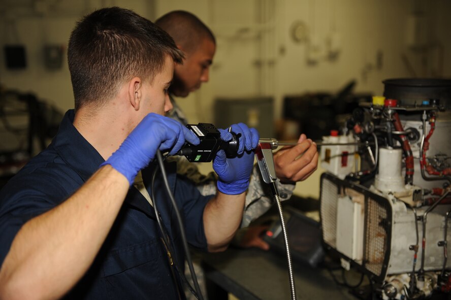 Airman 1st Class Kyle Mills (front), 4th Component Maintenance Squadron aerospace propulsion journeyman, uses a borescope to check for internal damage on a jet fuel starter on Seymour Johnson Air Force Base, N.C., Sept. 14, 2009. The borescope allows Airmen to check for internal damage without disassembling the engine part. (U.S. Air Force photo by Senior Airman Ciara Wymbs)