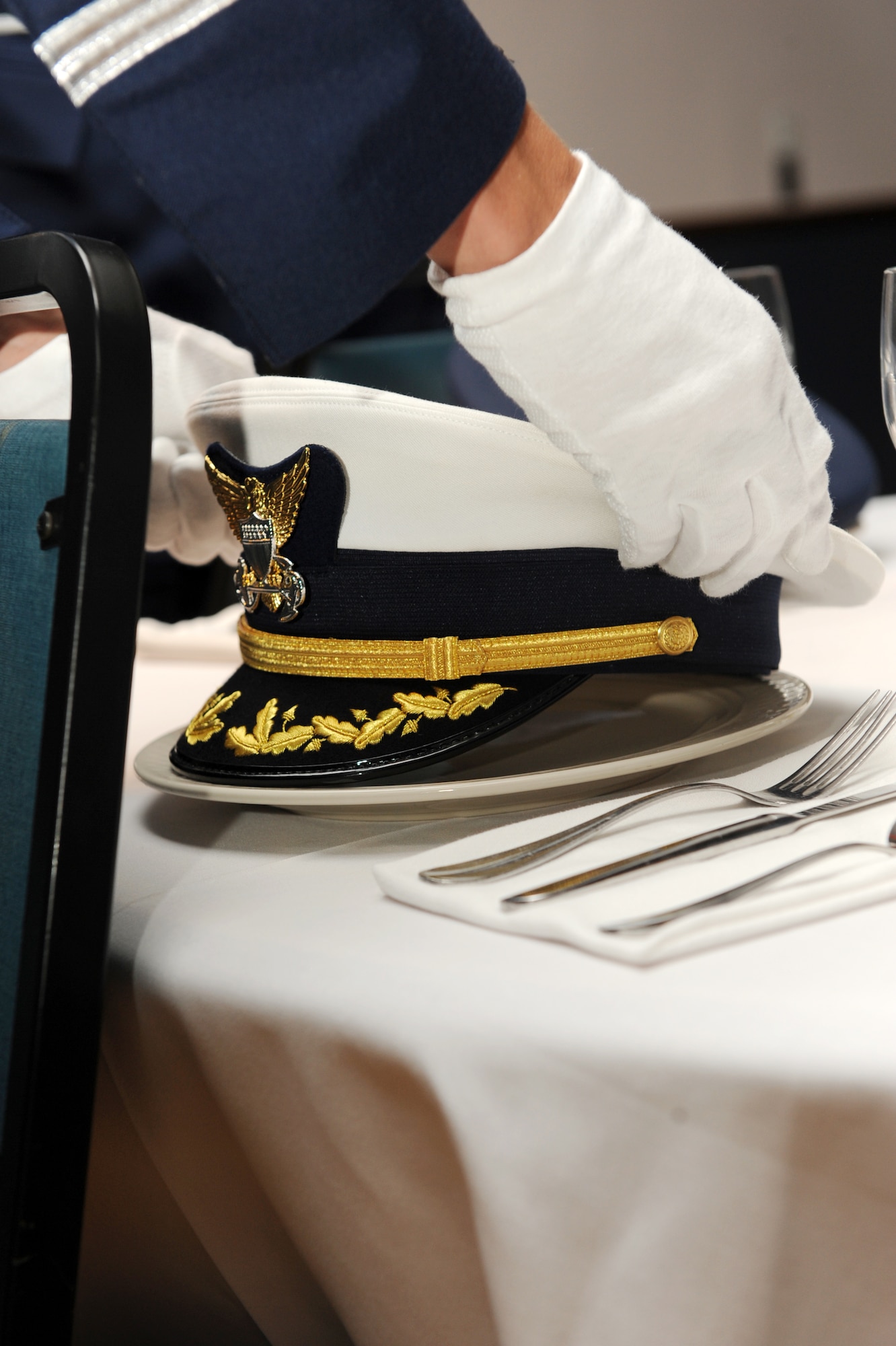 A Little Rock Air Force Base honor guardsman, places a Navy ceremonial cover on the POW/MIA table Sept. 18 as a tribute to those individuals who have paid the ultimate sacrifice for freedom. (US Air Force photo by Senior Airman Ethan Morgan)