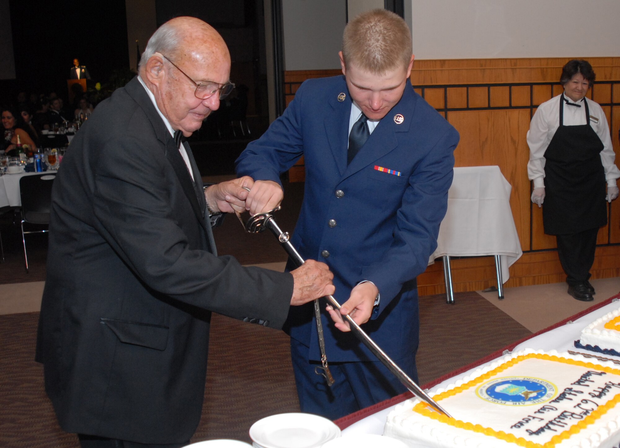 SAN ANGELO, Texas -- Retired Col. Charlie Powell, former 17th Training Wing commander, and Airman Basic Justin Youngblood, 315th Training Squadron student, cut the cake during the cake-cutting ceremony at the Goodfellow Air Force Base 2009 Air Force Ball, Sept. 18, 2009. It is tradition to have the oldest and youngest Airmen present cut the cake. (U.S. Air Force photo/Airman Clayton Lenhardt)