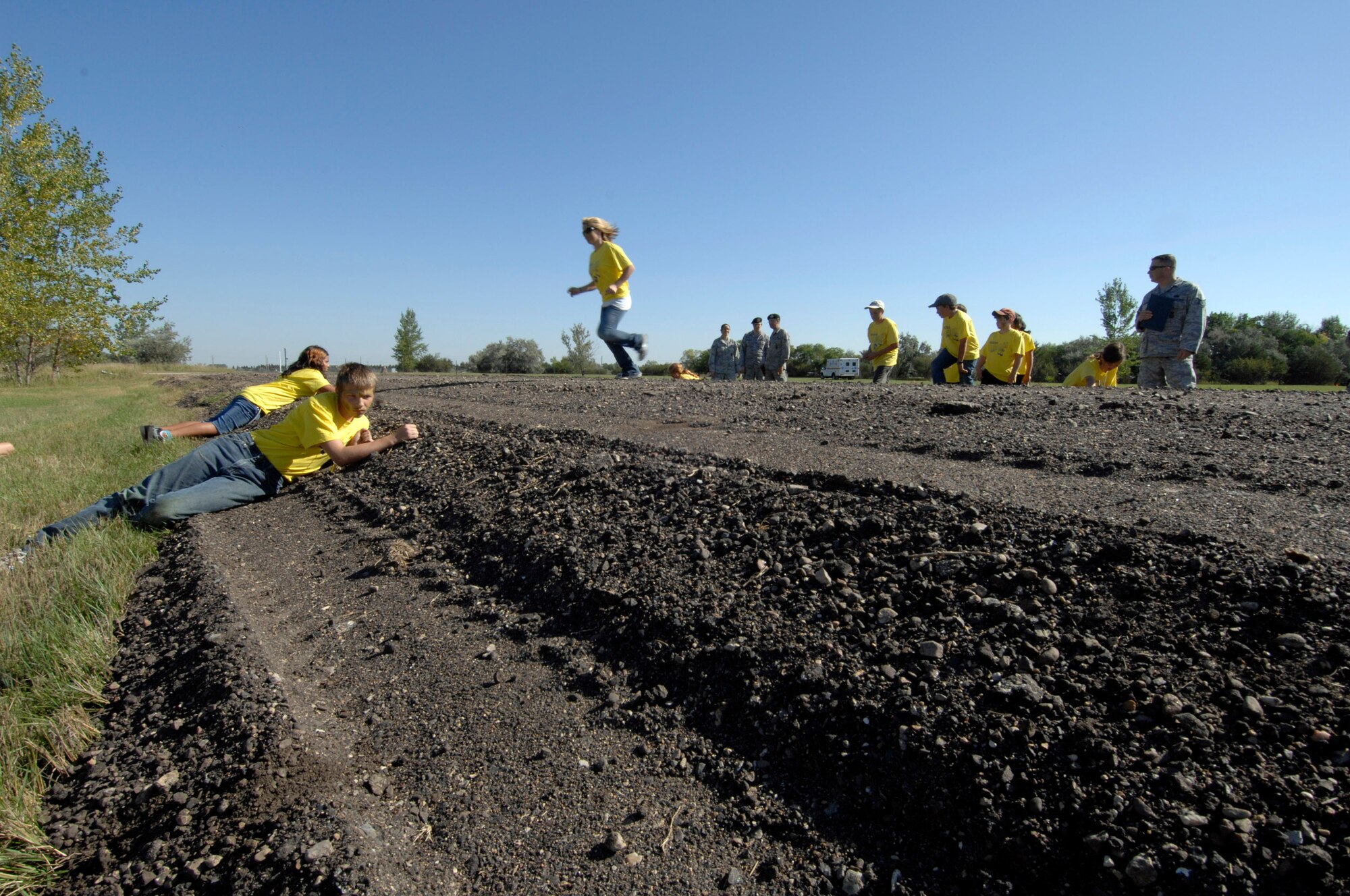 MINOT AIR FORCE BASE, N.D. -- Participants in Operation Heroes perform a danger crossing of a road here, Sept. 19.  Operations Heroes is an event for children to go through a mock deployment to simulate what their parents goes through when preparing to deploy. The older children went on a “special mission” where they learned military formation and how to detain suspects. (U.S. Air Force Photo by Senior Airman Matthew Smith)    