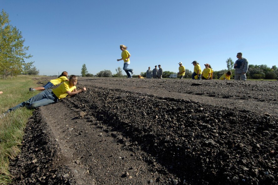 MINOT AIR FORCE BASE, N.D. -- Participants in Operation Heroes perform a danger crossing of a road here, Sept. 19.  Operations Heroes is an event for children to go through a mock deployment to simulate what their parents goes through when preparing to deploy. The older children went on a “special mission” where they learned military formation and how to detain suspects. (U.S. Air Force Photo by Senior Airman Matthew Smith)    