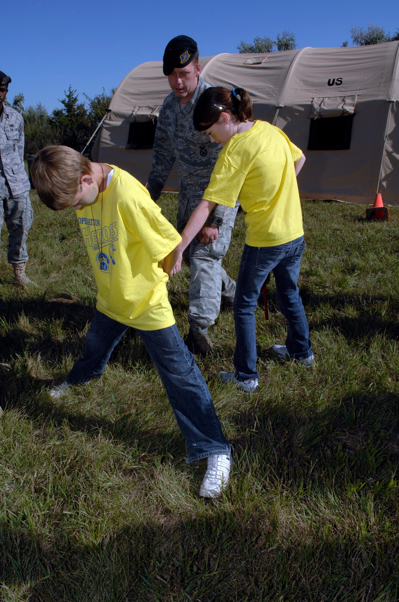MINOT AIR FORCE BASE, N.D. -- Senior Airman Michael Olson, 5th Security Forces Squadron, shows Participants in Operation Heroes how to approach a suspect here, Sept. 19.  Operations Heroes is an event for children to go through a mock deployment to simulate what their parents goes through when preparing to deploy. The older children went on a “special mission” where they learned military formation and how to detain suspects. (U.S. Air Force Photo by Senior Airman Matthew Smith)