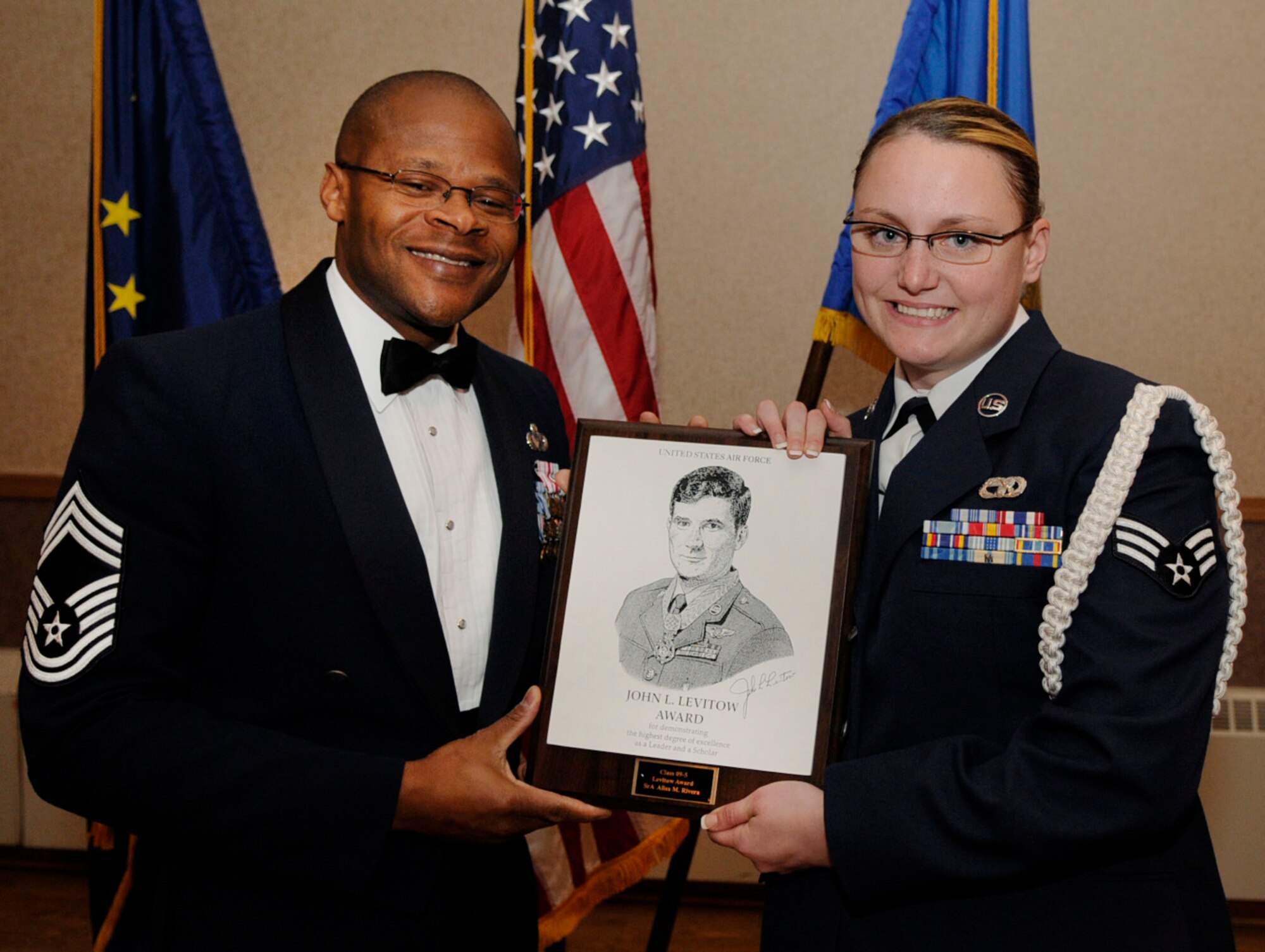 Chief Master Sgt. Willard Lacy presents Senior Airman Alisa Rivera the John L. Levitow award during the Airmen Leadership School graduation Sept. 14, 2009, Eielson Air Force Base, Alaska. The award is given to the outstanding Airman of the class who has the highest grades and is voted as a class leader by their peers. John L. Levitow is the lowest ranking Airman to earn the Medal of Honor in 1969 during the Vietnam War. Chief Lacy is assigned to the 354th Medical Support Squadron and Airman Rivera is assigned to the 168th Logistics Readiness Squadron. (U.S. Air Force photo/Airman 1st Class Laura Goodgame)