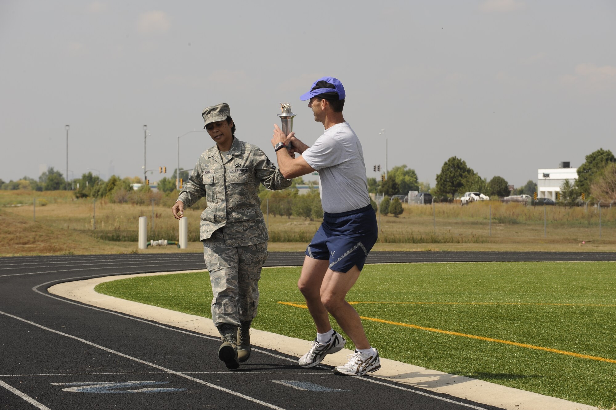 460th Space Wing Command Chief Master Sgt. Arleen Heath is the first to pass the torch during the POW/MIA ceremony and torch run held at the base track, Sept. 17. (U.S. Air Force photo by Senior Airman Steven Czyz)