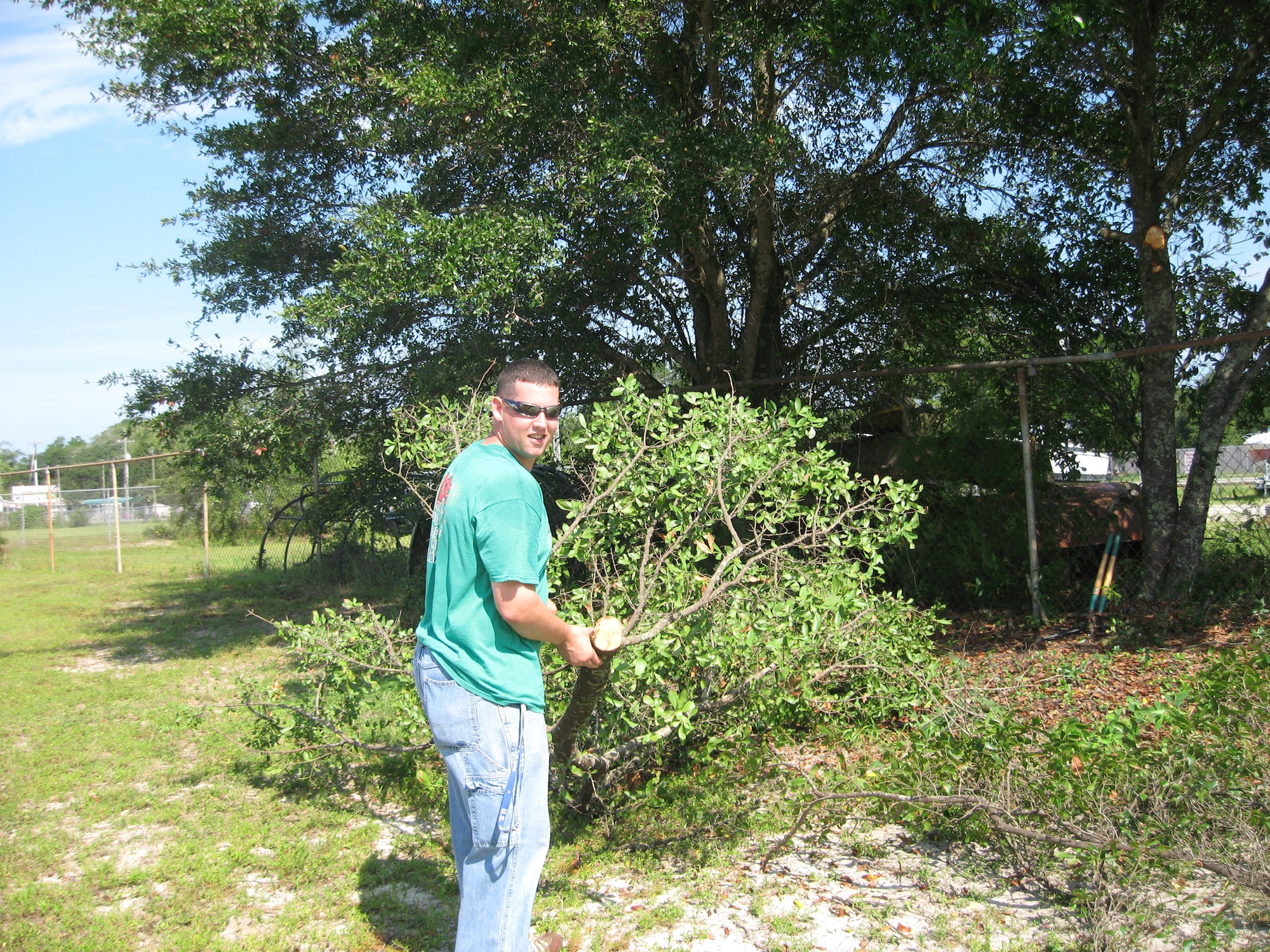 Staff Sgt. Brandon Signorotti, 325th Aircraft Maintenance Squadron F-15 Weapons Load Crew Team chief, hauls away cut tree limbs in efforts to clean up Oscar Patterson Elementary for them to open for the school year as scheduled.  (Courtesy photo)  