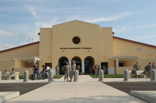 Military servicemembers returning from deployment Sept. 11, 2009 catch a breath of fresh air outside the main entrance of the 724th Air Mobility Squadron's new passenger and air freight terminal at Aviano Air Base, Italy while the military chartered aircraft carrying them home is serviced.  Passenger service agents from the 724th AMS began processing passengers through the new facility Sept. 10. Volunteers supporting Operation Yellow Ribbon provide snacks and other goodies to servicemembers transiting through the terminal.  (U.S. Air Force photo/Airman 1st Class Ashley Wood)