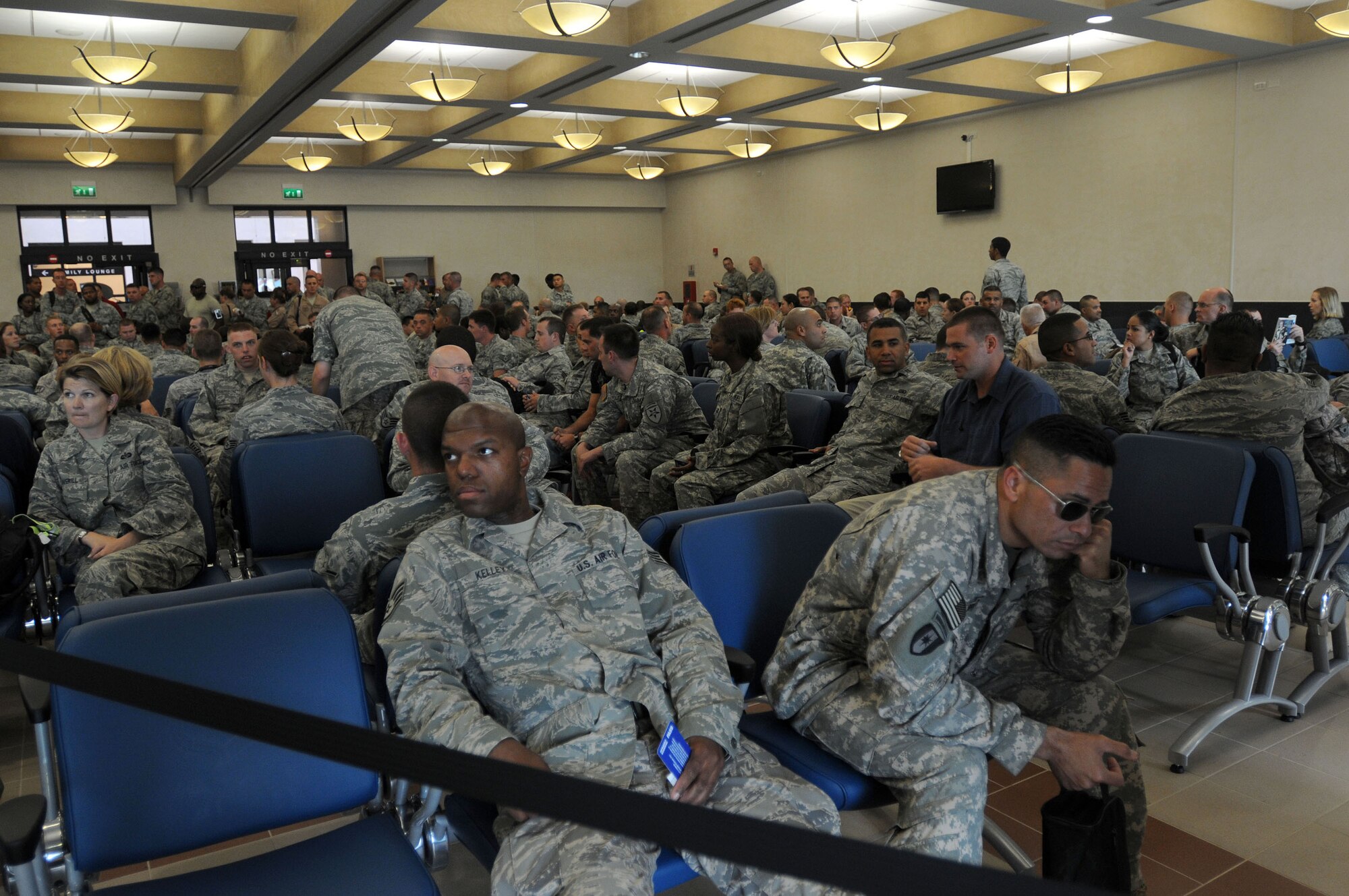 Military servicemembers returning from deployment Sept. 11, 2009 sit inside the gate area of the 724th Air Mobility Squadron's new passenger and air freight terminal at Aviano Air Base, Italy while the military chartered aircraft carrying them home is serviced.  Passenger service agents from the 724th AMS began processing passengers through the new facility Sept. 10. Volunteers supporting Operation Yellow Ribbon provide snacks and other goodies to servicemembers transiting through the terminal.  (U.S. Air Force photo/Airman 1st Class Ashley Wood)