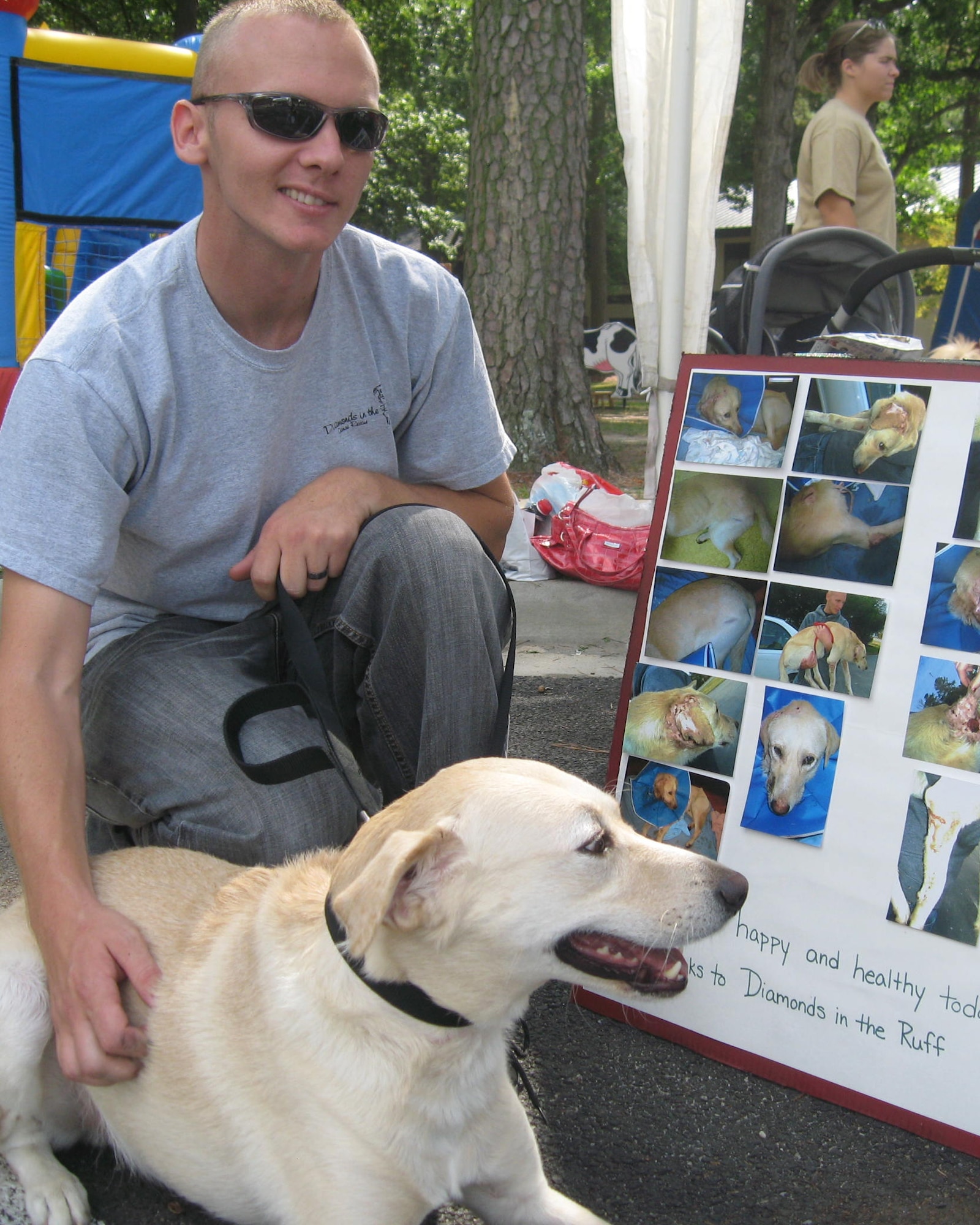 Staff Sgt. Travis Davis, 4th Civil Engineer Squadron unaccompanied housing manager, pets his dog Lucky during a Pet Fair hosted by the Southern Pines Inn on Seymour Johnson Air Force Base, N.C., Sept. 19, 2009. The poster by Sergeant Davis’ side chronicles the condition Lucky was in when he was rescued by Diamonds in the Ruff and the care the non-profit organization provided for him. The agency saved Lucky’s life. (U.S. Air Force photo by Tech. Sgt. Tammie Moore)