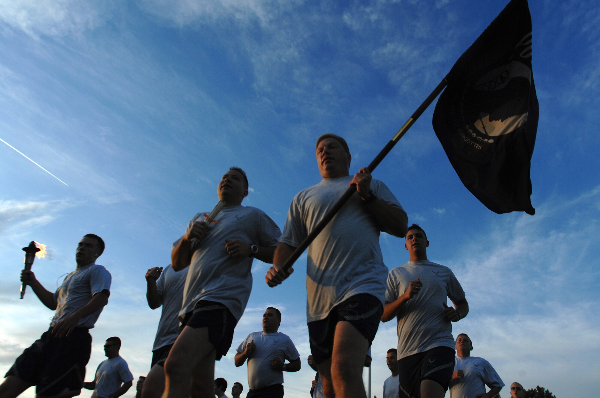 WHITEMAN AIR FORCE BASE, Mo. - Members of the 509th Maintenance Group run hard with the POW/MIA flag and torch, Sept. 18. The POW/MIA run is a 24-hour torch and flag run to honor prisoners of war and missing-in-action personnel. Staff Sgts. Amir Hasan and Brandon Lines, 509th Munitions Squadron, organized the 24-hour run and scheduled it to kick off at 6 a.m. the morning of the Air Forces 62nd anniversary. Several military and civilian personnel from 24 different organizations participated in the run. (U.S. Air Force photo/Senior Airman Kenny Holston)