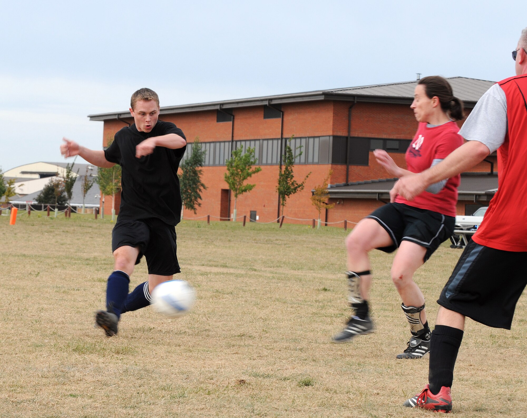 RAF MILDENHALL, England -- Philip Rosen, 100th Force Support Squadron player, attempts to battle past blockers from the 100th Operations Group in intramural soccer play near the Hardstand Fitness Center here Sept. 21. The FSS put up quick numbers and kept OG to a single goal to take the win 4-1. Rosen later scored one of OG's goals. (U.S. Air Force photo/Senior Airman Thomas Trower)