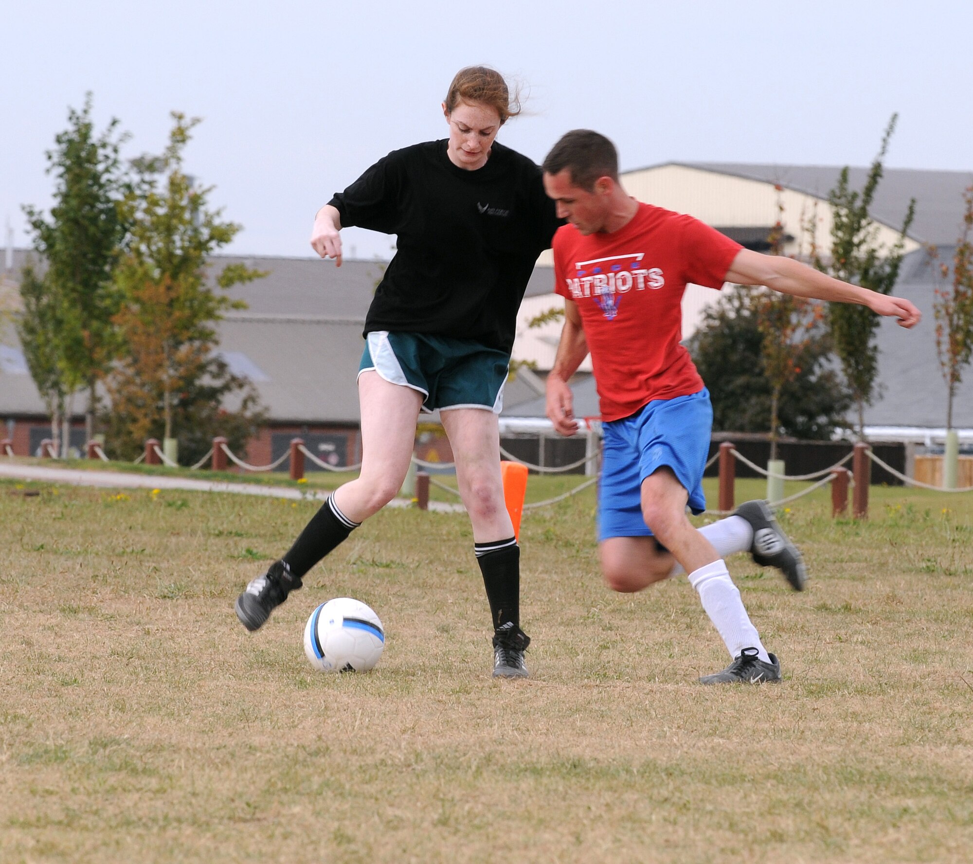 RAF MILDENHALL, England -- Pete Shayhorn, 100th Operations Group player, makes an unsuccessful attempt to steal the ball from Bethany "Mantis" Mettes in an intramural soccer match near the Hardstand Fitness Center here Sept. 21. The 100th OG fought hard against the 100th Force Support Squadron, although being two players short proved too difficult an obstacle to overcome and OG lost the match 1-4. The 100th FSS lead scorer, Jonathan Fraher, placed two goals under his belt and was assisted in the win by single goals from Philip Rosen and Carlos Sanchez. Shayhorn was the sole OG scorer. (U.S. Air Force photo/Senior Airman Thomas Trower) 