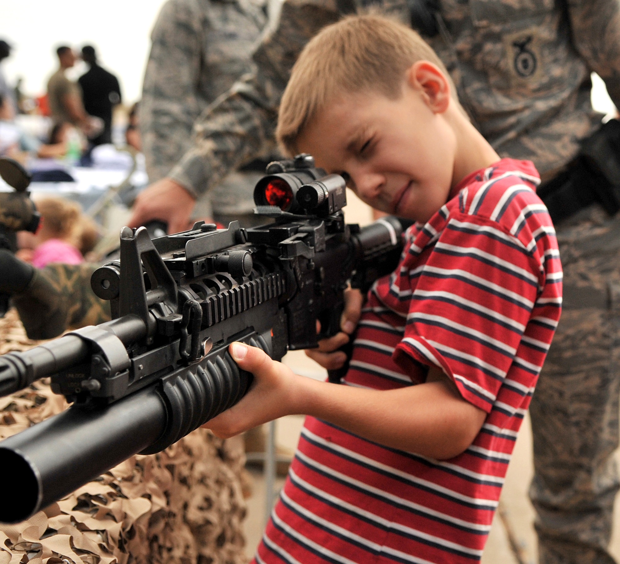CANNON AFB, N.M.--Caleb Chambers looks at an M-4 carbine with an M-203 grenade launcher at the security forces display booth during Commando Family Day here Sept. 19.  Squadrons from around the base displayed items that demonstrated their capabilities.  (U.S. Air Force photo by Staff Sgt. Heather R. Redman/RELEASED)