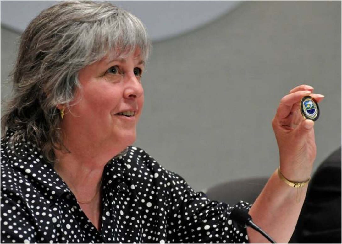 Spokane County District 3 Commissioner Bonnie Mager holds out a 141 Air Refueling Wing  coin to show the audience after the coin was presented to her by Col. Greg Bulkley. 
