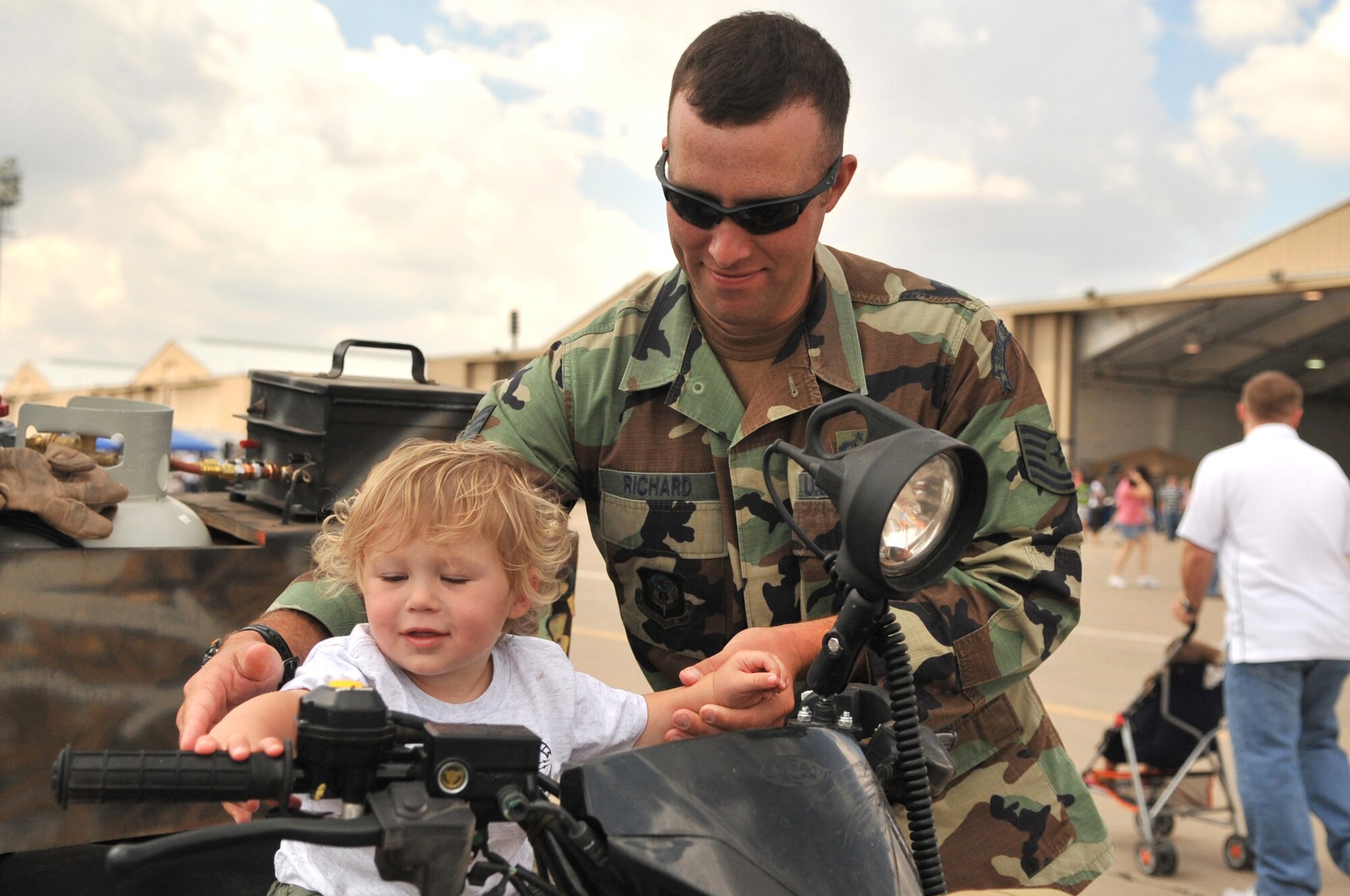 CANNON AFB, N.M.--Tech. Sgt. Marc Richard, 27th Special Operations Support Squadron, helps his son Conner Richard sit on an all terrain vehicles during Commando Family Day here Sept. 19.  ATVs are used for easier movement during training exercises around the base and local areas.  (U.S. Air Force photo by Staff Sgt. Heather R. Redman/RELEASED)
