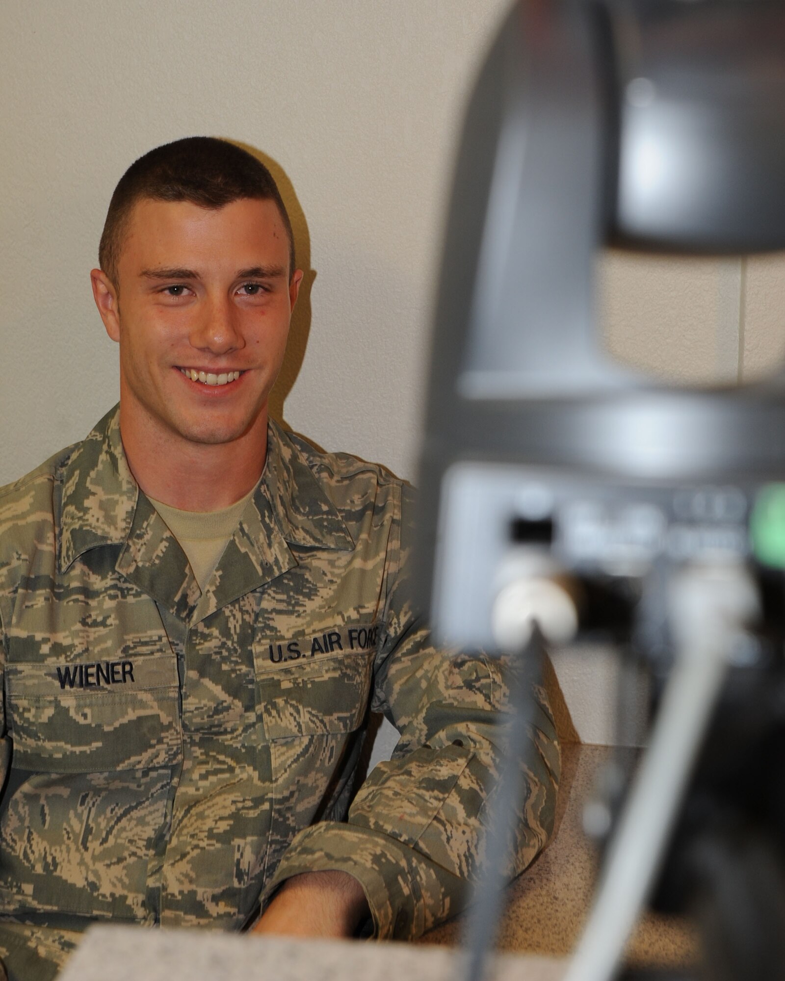 Airman First Class Francis Wiener, 22nd Civil Engineer Squadron, smiles for a camera, Sept. 16, 2009, at McConnell Air Force Base, Kan.  Airmen must take a photo each time they get a new military identification card. (U.S. Air Force photo/Tech. Sgt Chyrece Campbell)