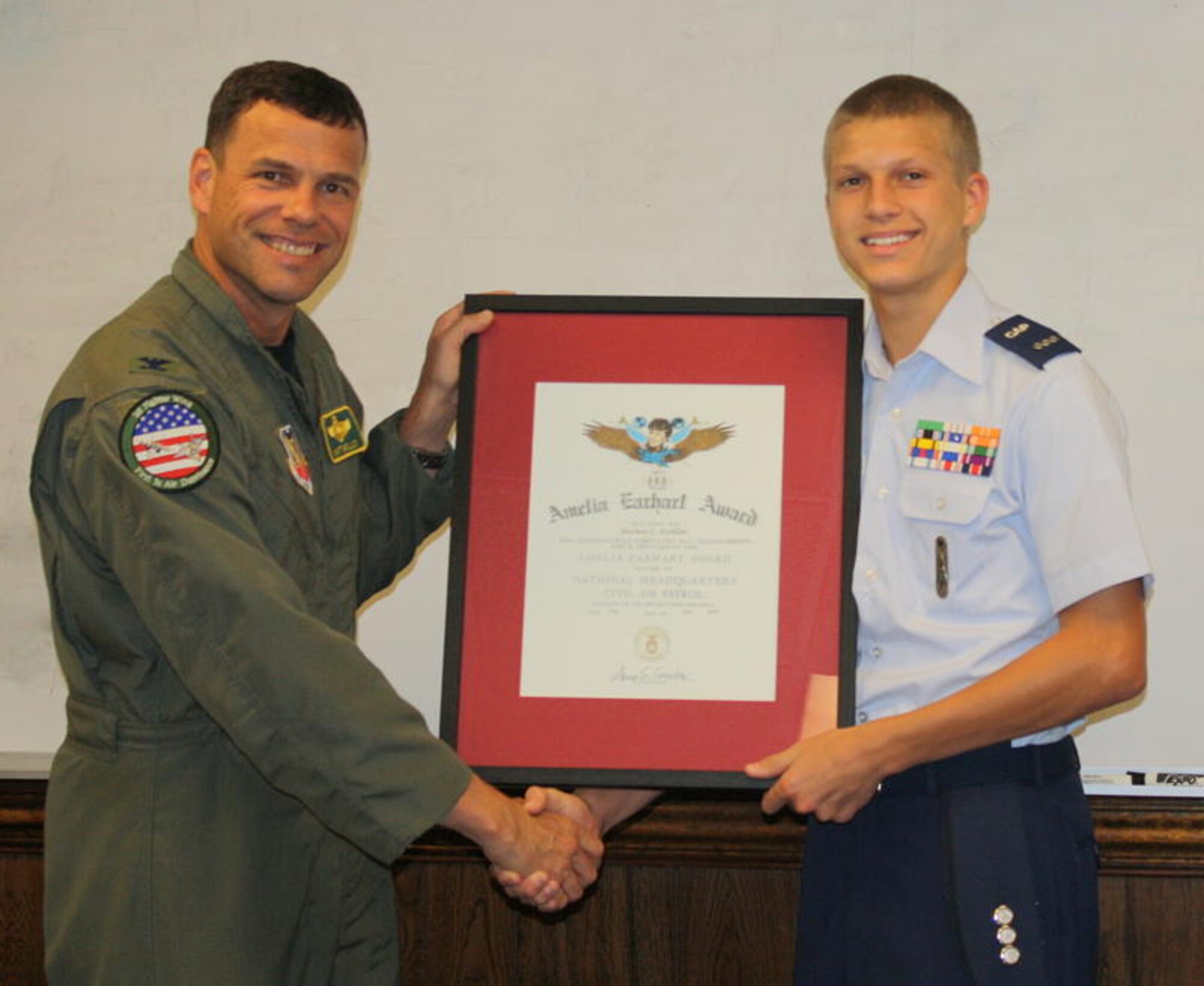LANGLEY AIR FORCE BASE, Va. -- Air Force Col. Matt Molloy, 1st Figher Wing commander, presents Civil Air Patrol Cadet Capt. Mathew Kubilins with the Amelia Earhart Award Sept. 14. The award represents Cadet Kubilins' completion of Phase III of the CAP cadet program, an accomplishment achieved by only five per cent of all cadets nationwide. (Civil Air Patrol photo/TFO Jackie Barton)