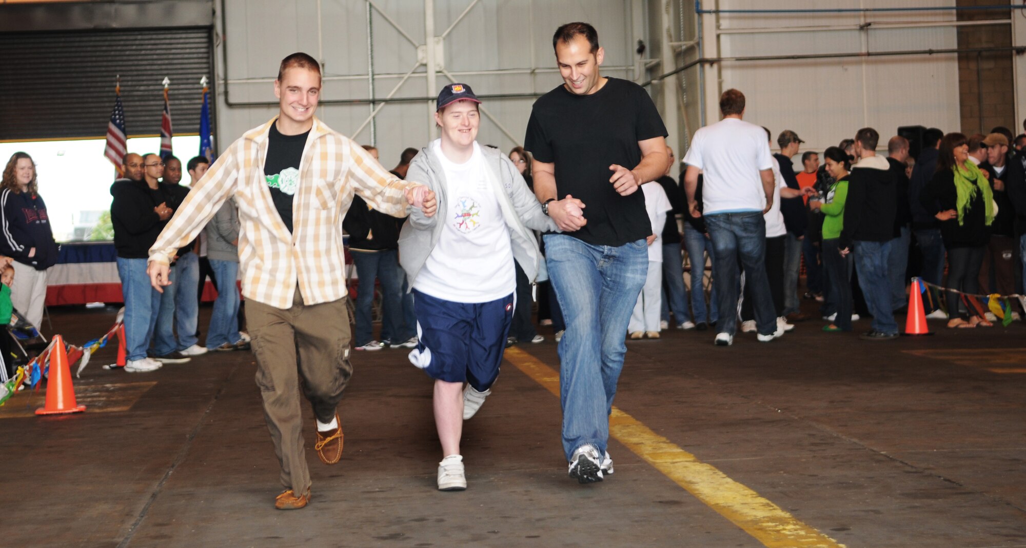 RAF MILDENHALL, England -- Airman 1st Class Ian Shea (left) and Staff Sgt. Keith Pierson (right), 100th Logistics Readiness Squadron, help Billy Hopkins prepare to compete in the 50-yard dash at the 28th Annual Joan Mann Special Sports Day at Hangar 711 Sept. 19. Billy was an athlete competing in the event dedicated to special-needs players. Billy was competing in the basketball shoot and bowling as well. (U.S. Air Force photo/Senior Airman Thomas Trower)
