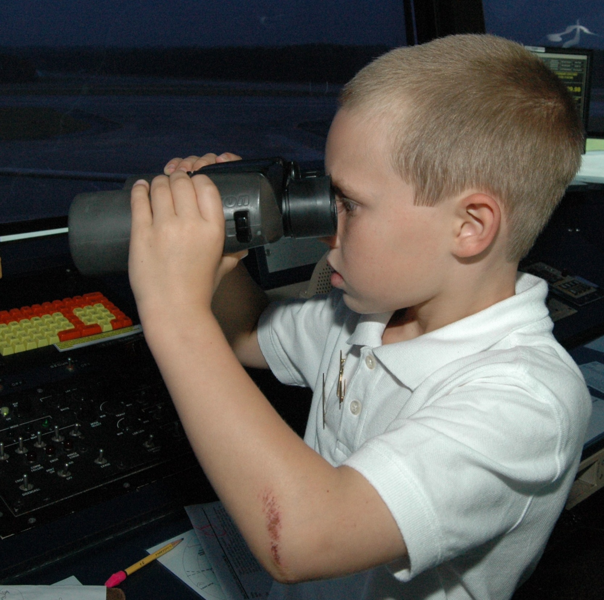 Jeremy Payne, 8, peers through binonculars while touring the Dobbins air traffic control tower Sept. 15. Jeremy was able to try his hand at flying a C-130 simulator, coordinating air traffic on the ATC simulator, received night-vision goggles training, attended pre-flight briefings and viewed a C-130 formation take off from the control tower. 