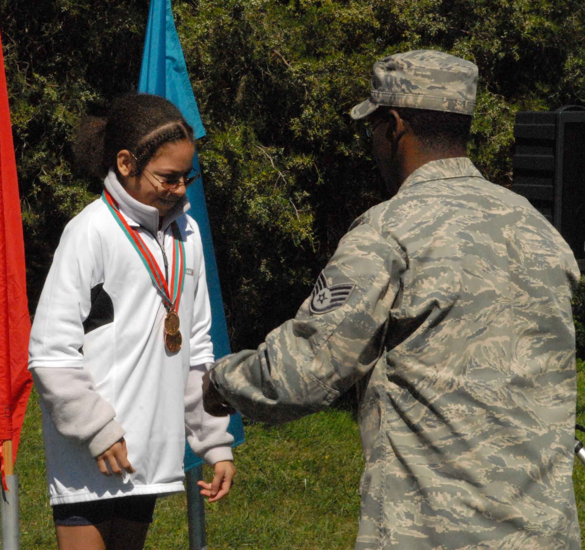 Staff Sgt. Roderick Tumblin, 436th Logistics Readiness Squadron, awards the bronze medal to a Special Olympics competitor Sept. 19.  (U.S. Air Force photo/Staff Sgt. Chad Padgett)